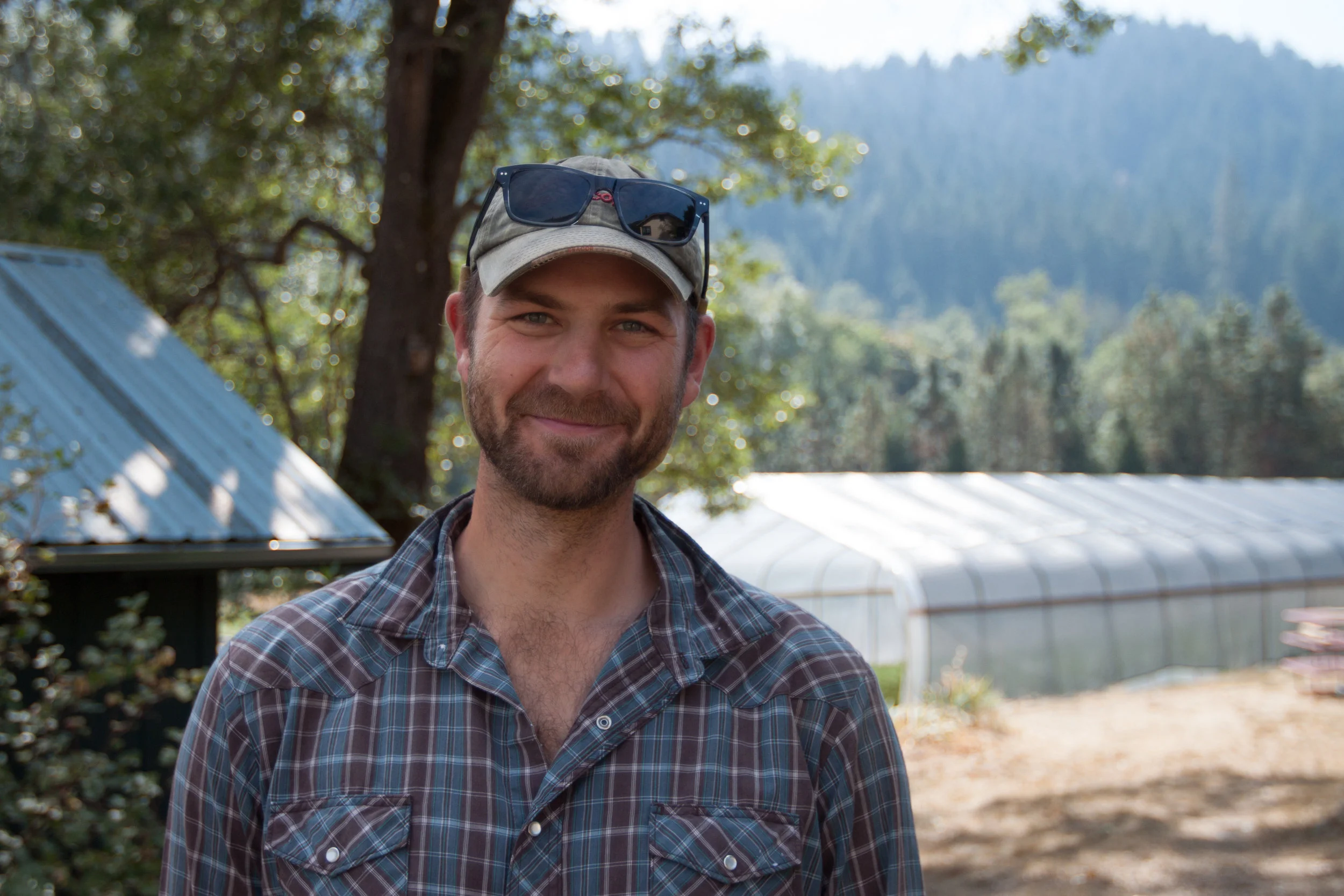 Owner Andrew Schwarz stands in the shade of a large oak tree on his farm.