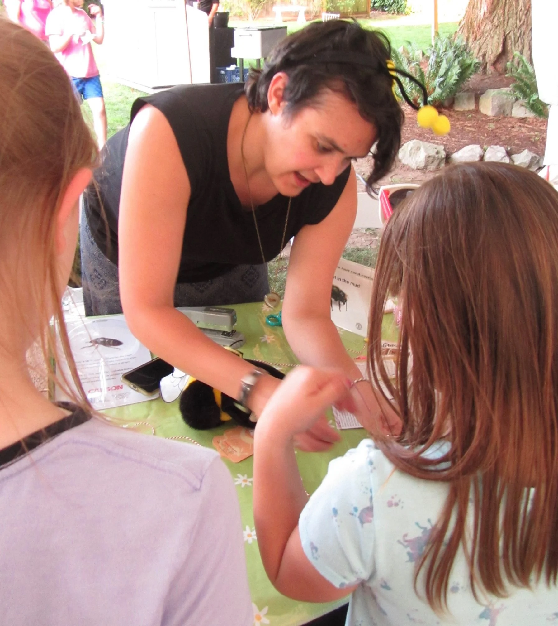 Rachel Phariss bee teaching buzz cards at Rock Creek Neighborhood Night Out, with Larry Hill and Missy Martin.