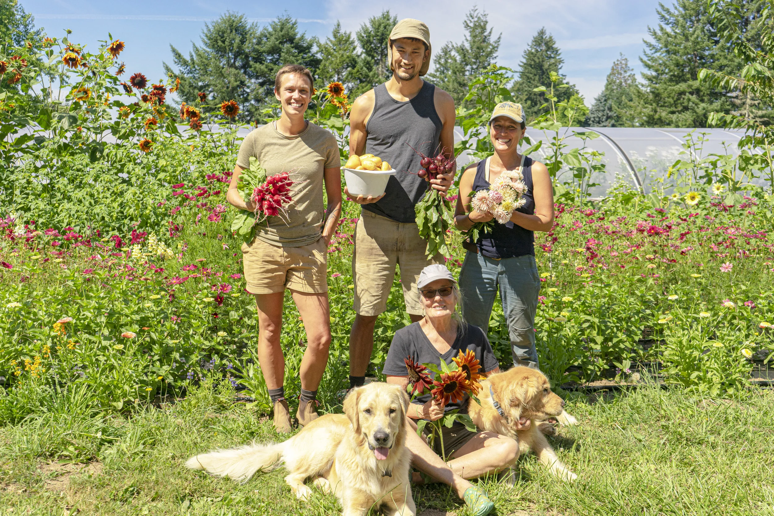 Brindley, Spencer, Jennie, and Pam posing with fresh goods from their farm. (Left to Right)
