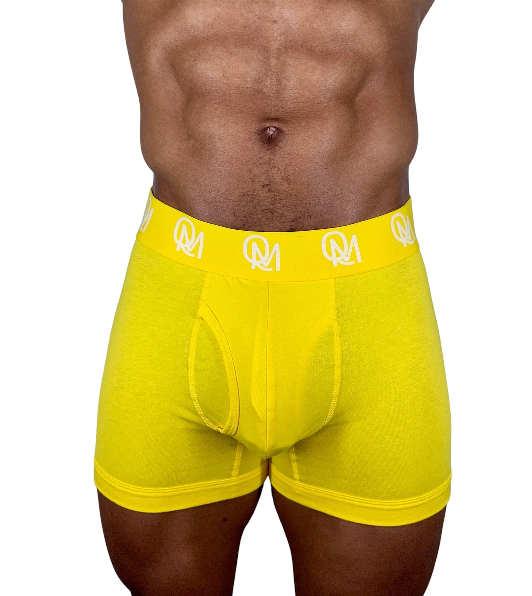 Model wearing yellow Quennell Mitchell men’s boxer briefs with white QM logo waistband.