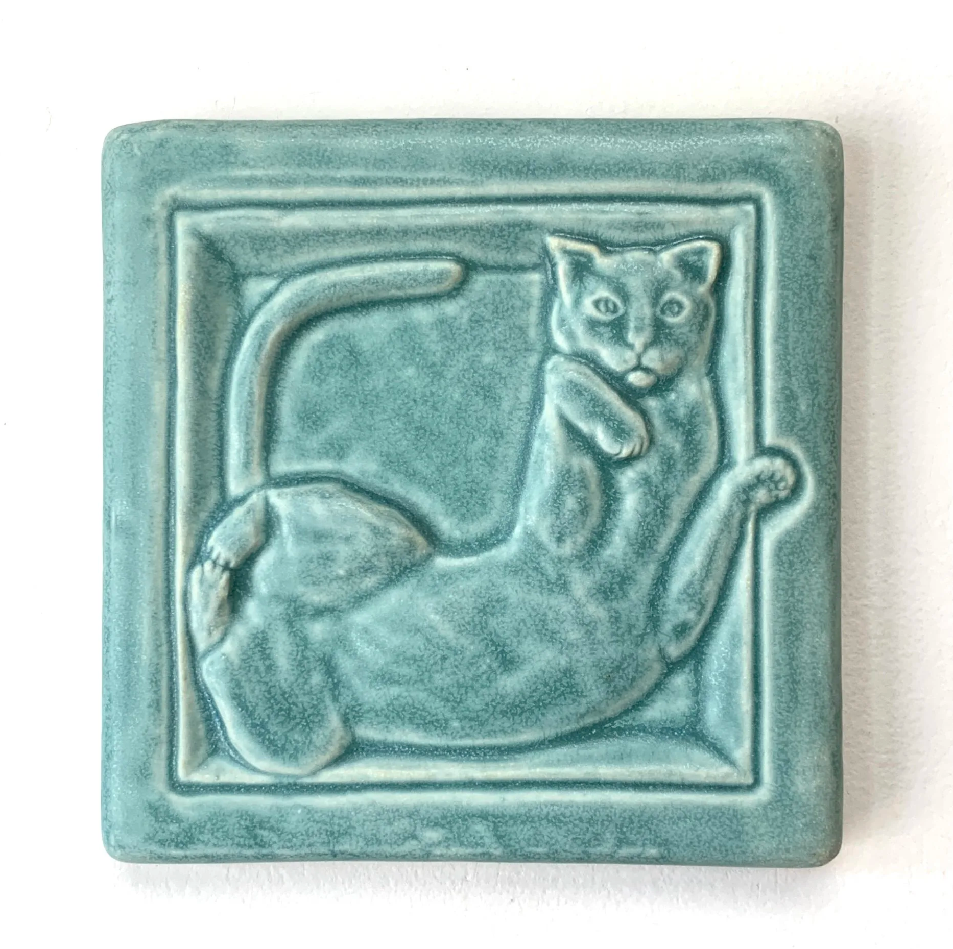 Handmade 4x4 porcelain Cat in Box art tile. Michigan artisan ceramic for kitchen backsplashes and whimsical pet-themed wall decor. Moisture-resistant feline relief sculpture.
