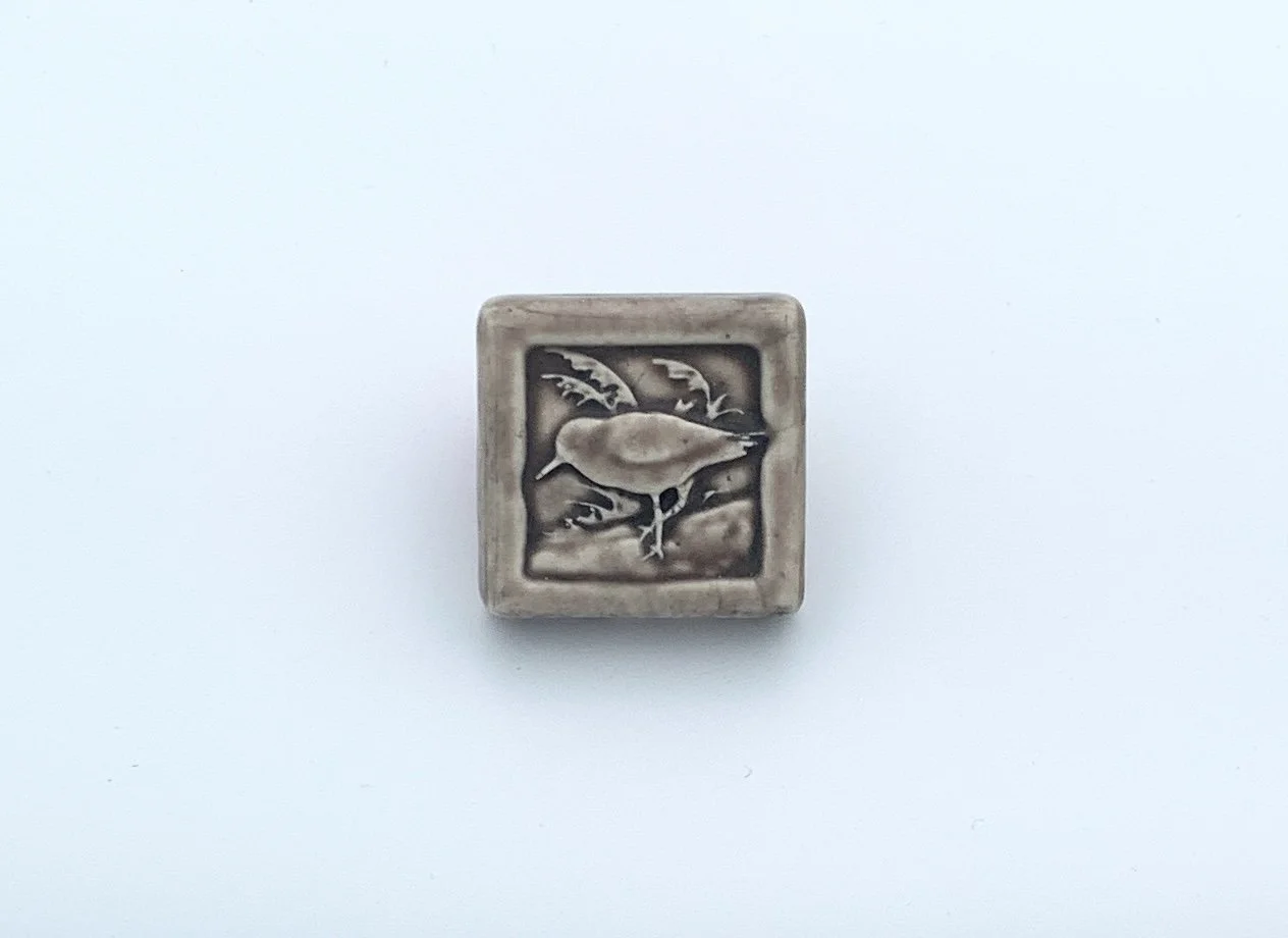 Handmade 2x2 porcelain Sandpiper art tile by Rick Pruckler and Tonya Lutz. Michigan artisan ceramic for DIY backsplashes and coastal wall decor. Moisture-resistant beach-themed gift.