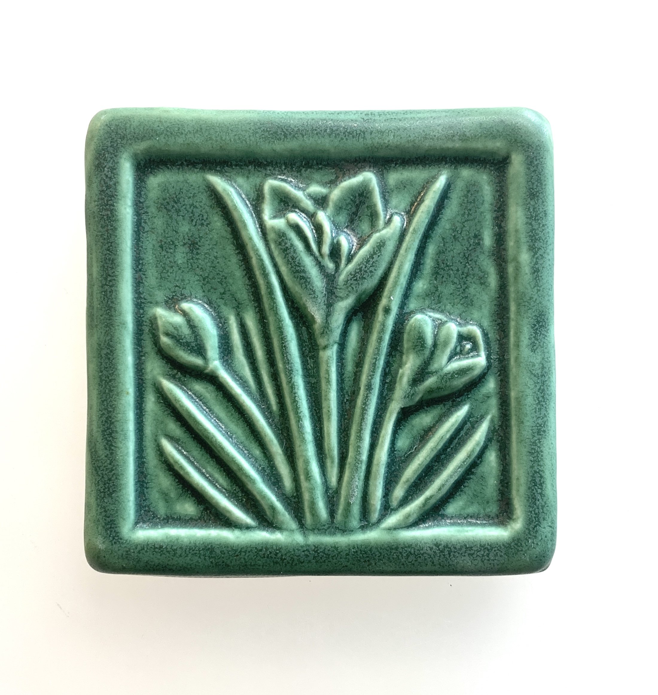 Handcrafted 4x4 inch Whistling Frog Crocus art tile in a matte glaze, featuring a raised crocus flower design, suitable for gifting, or tile installation in kitchen, bathroom, or fireplace.