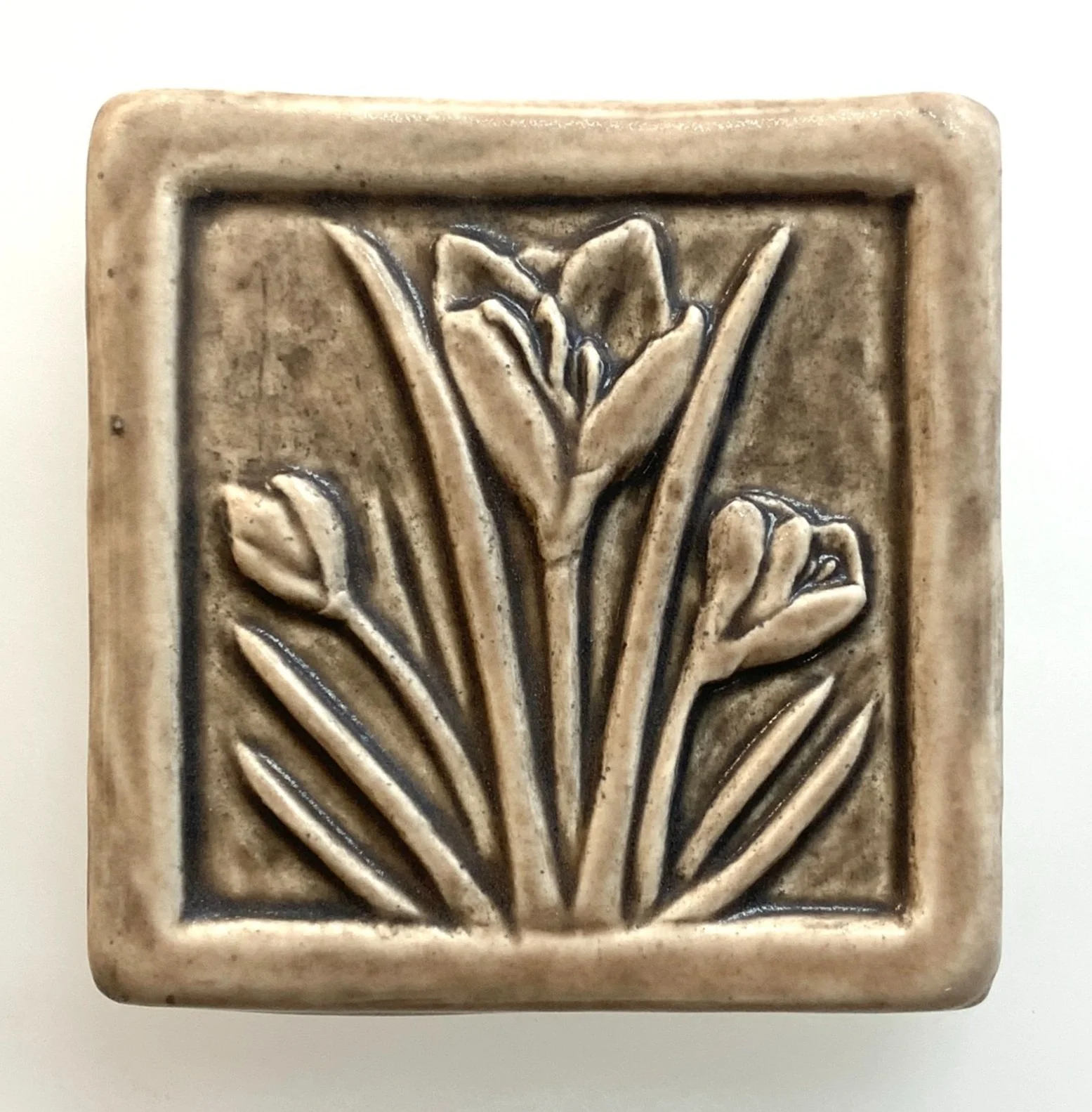 Handcrafted 4x4 inch Whistling Frog Crocus art tile in a matte glaze, featuring a raised crocus flower design, suitable for gifting, or tile installation in kitchen, bathroom, or fireplace.