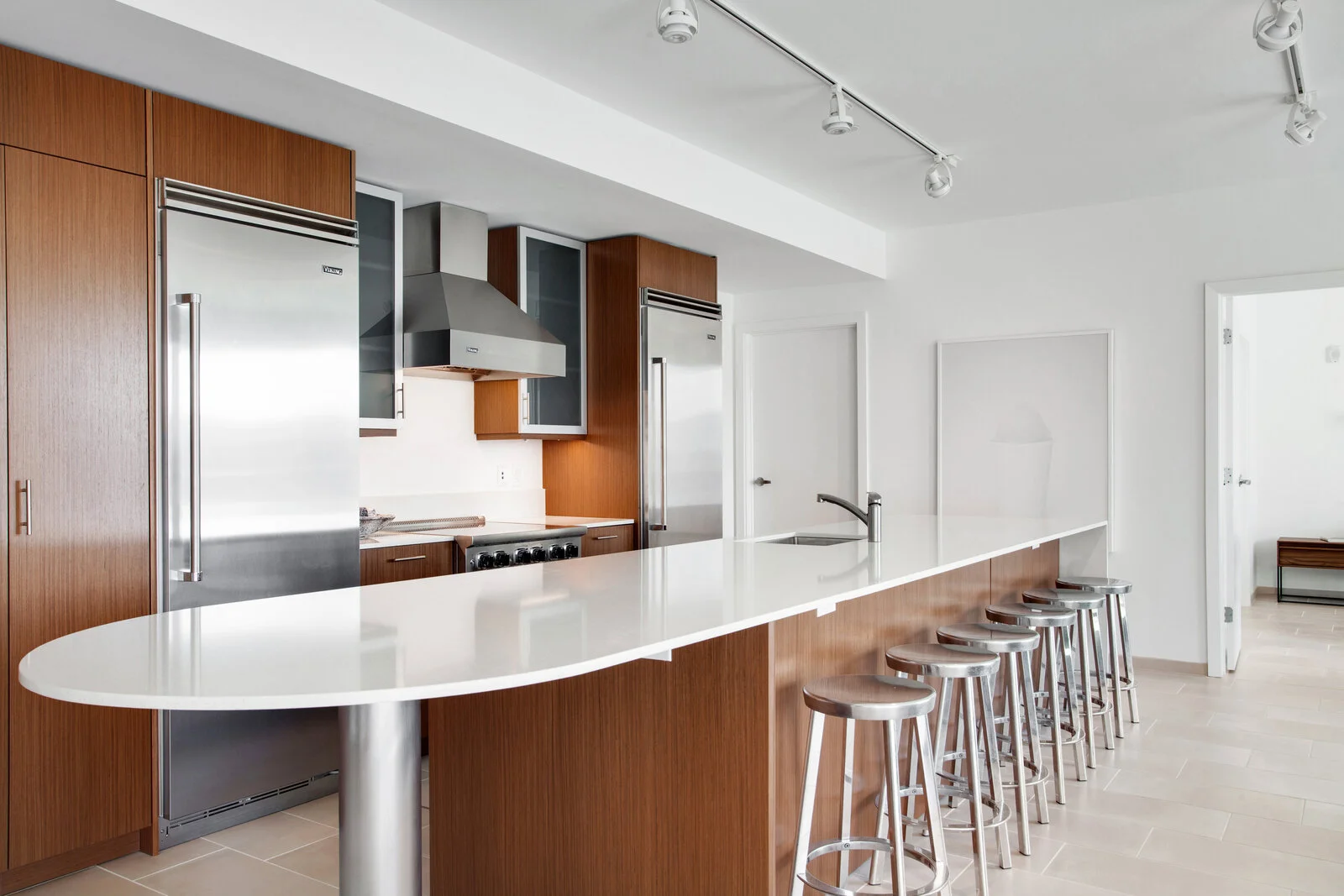  Apartments in Warehouse District - The Garage - Kitchen with White Quartz Bar, High Stools, and Stainless-Steel Appliances 