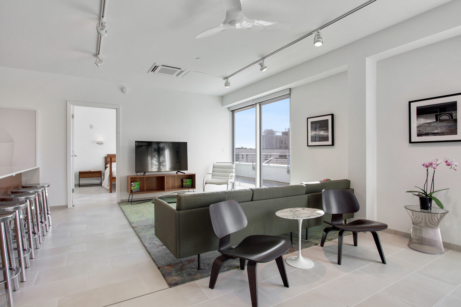  Luxury Apartments New Orleans - The Garage Spacious and Open Living Room with Tile Flooring, Track Lights, and Access to Balcony 