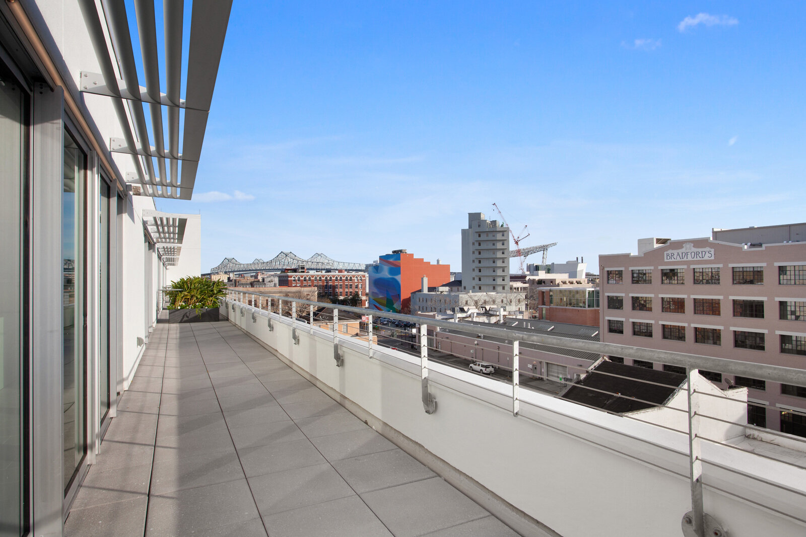  Apartments in Warehouse District LA - The Garage - Spacious Balcony with Tiled Concrete Ground, Metail Rail, Large Windows, and Expansive City Views 
