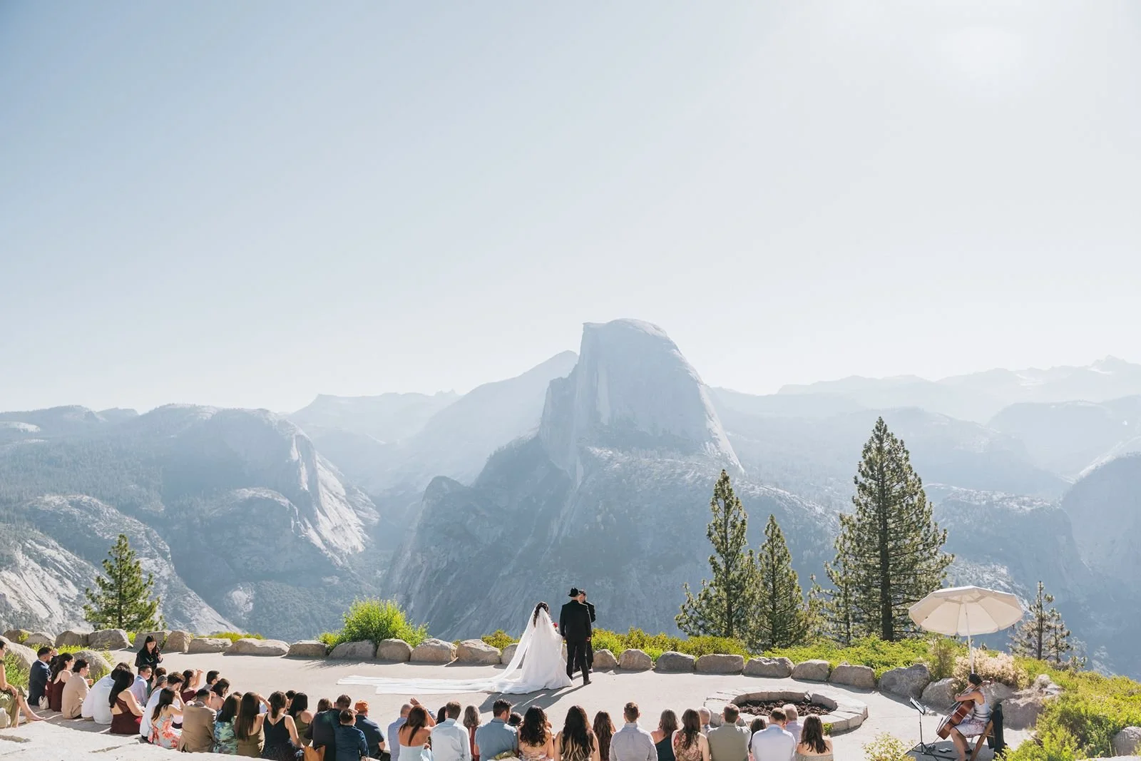 Outdoor wedding ceremony with 50 guests at the Glacier Point Amphitheater in Yosemite National Park during summer.