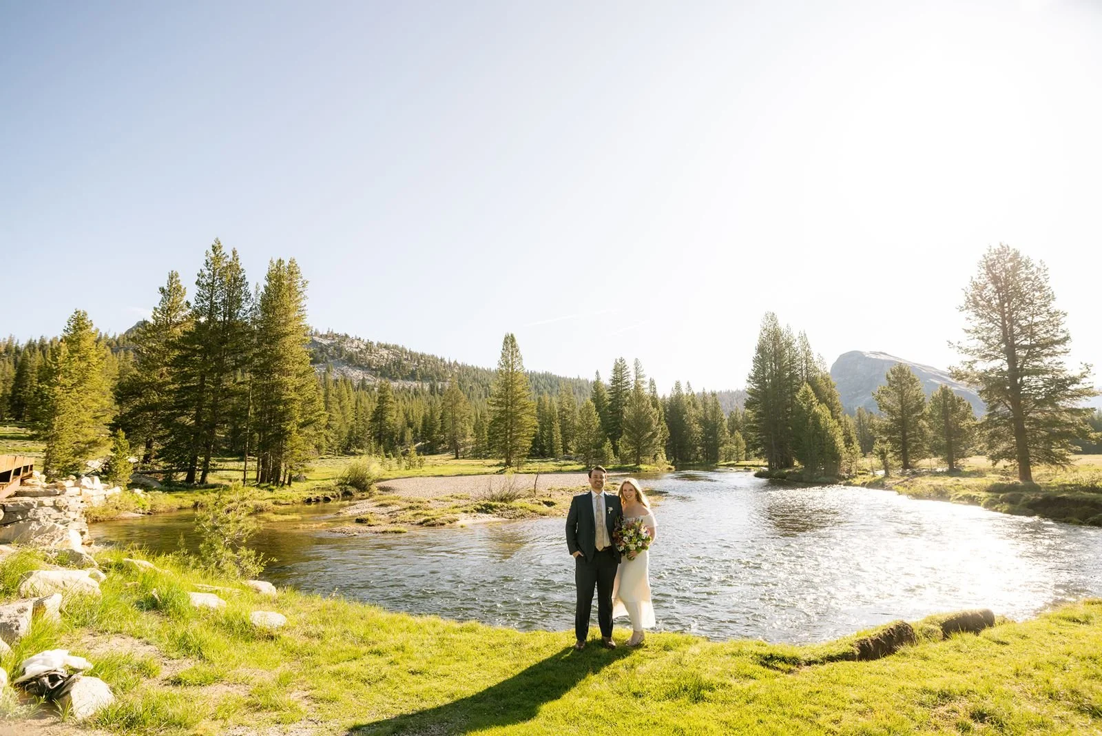Bride and groom celebrate their wedding at Tenaya Lake, framed by the breathtaking landscape of Yosemite National Park.