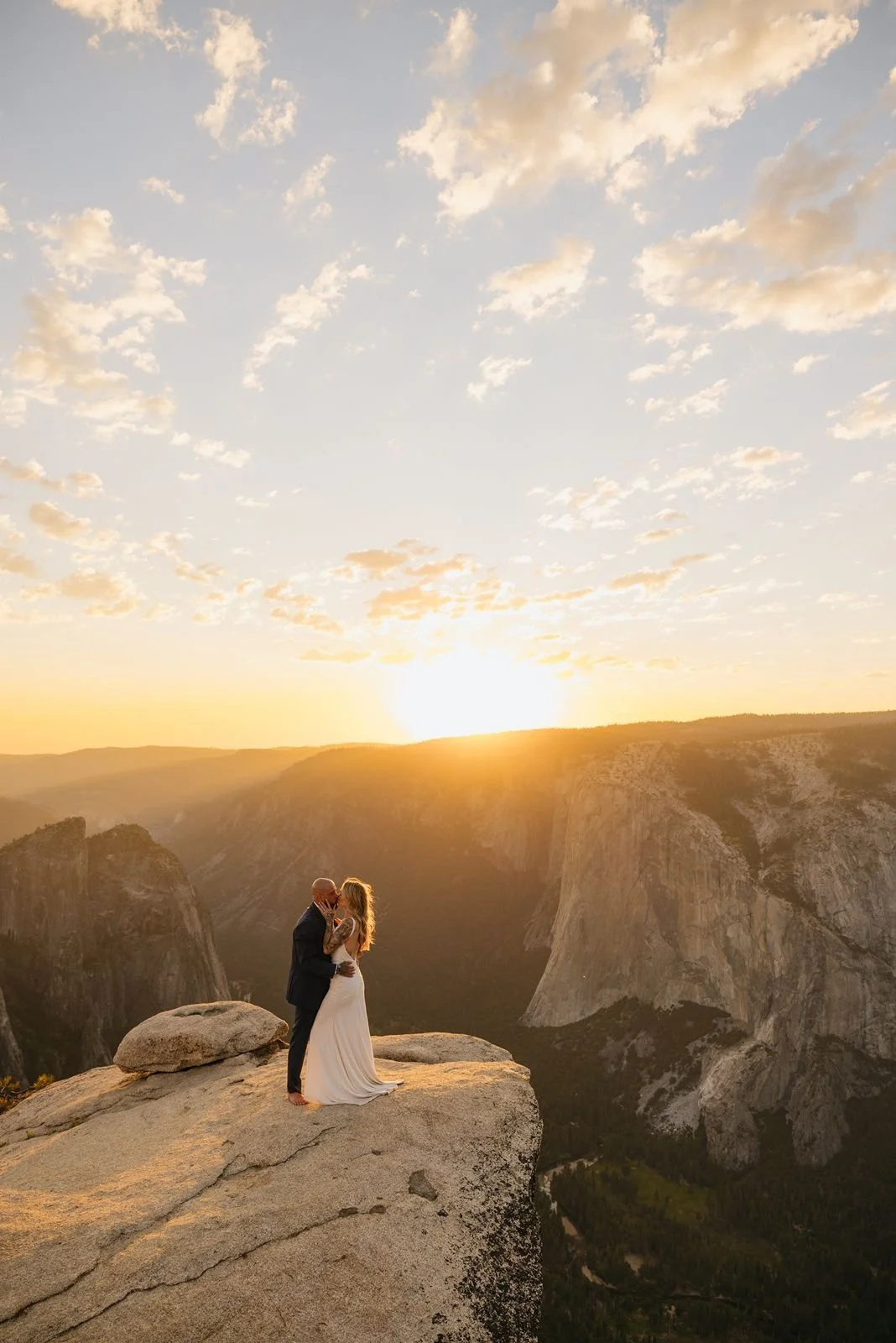 Bride and groom share a kiss at the top of Taft Point for a sunset wedding
