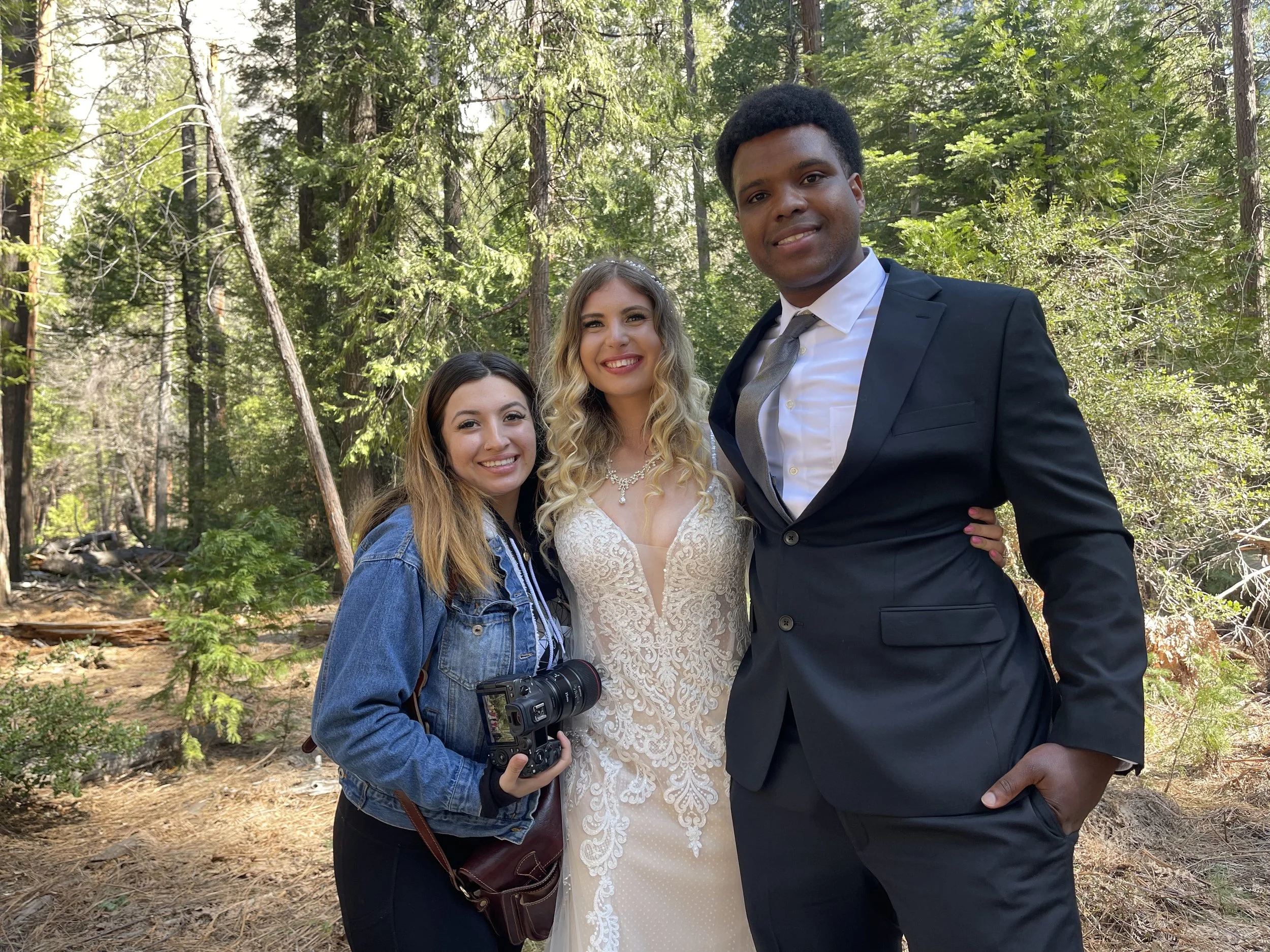 Professional wedding photographer Priscilla Banuelos posing with a bride and groom at Lower Yosemite Falls.