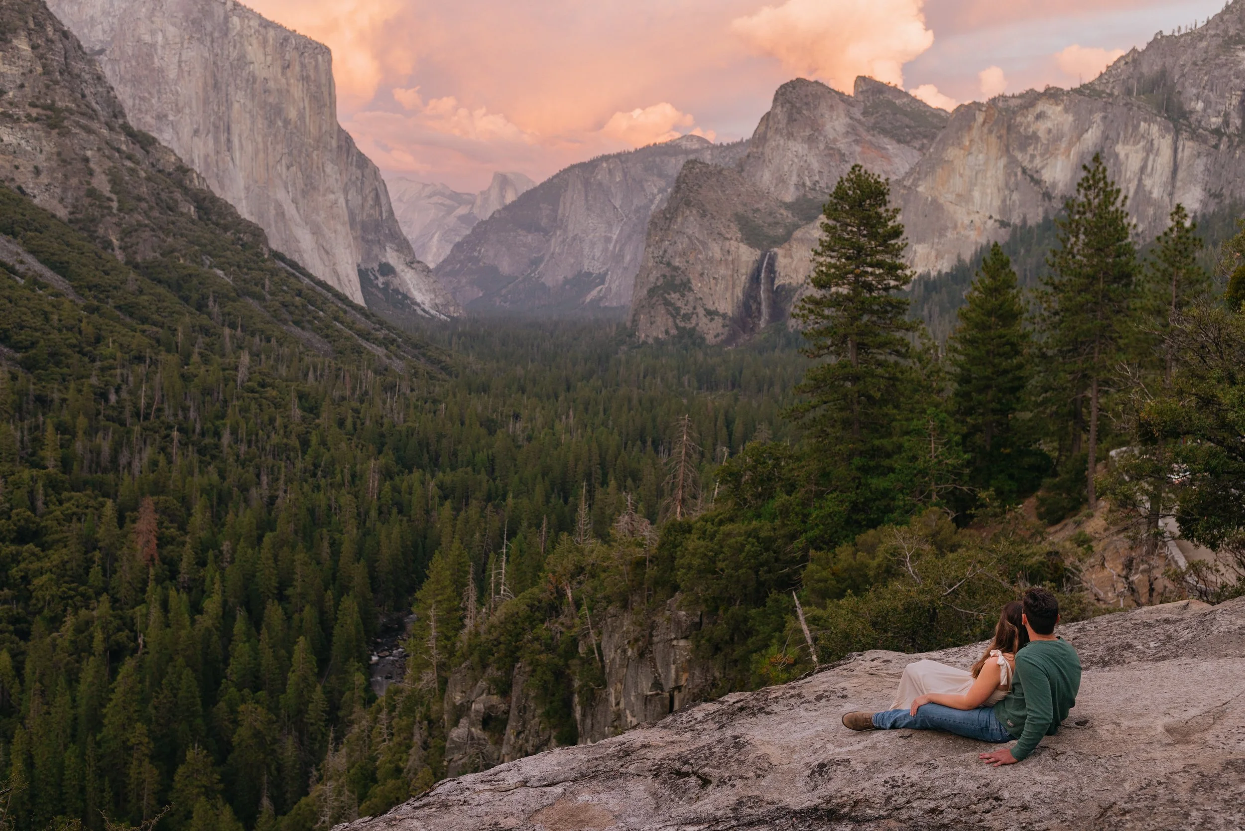 Warm sunset light illuminating the granite cliffs of Yosemite Valley as seen from an overlook.