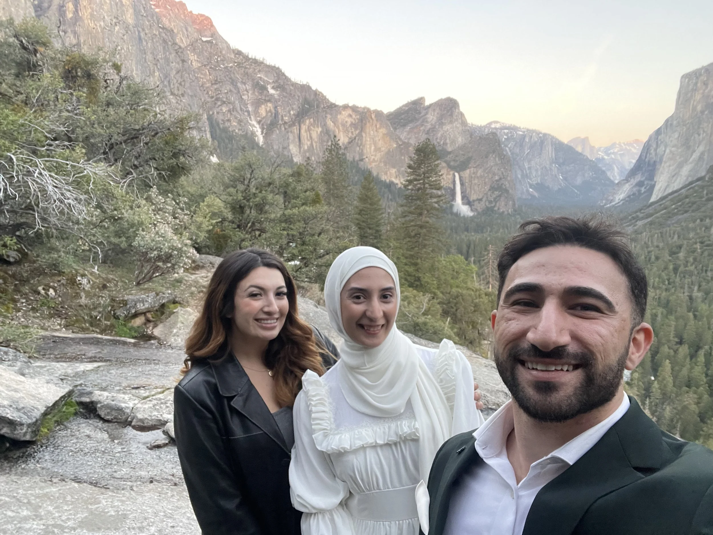 Professional photographer Priscilla Banuelos posing with a bride and groom at Tunnel View, Yosemite National Park.