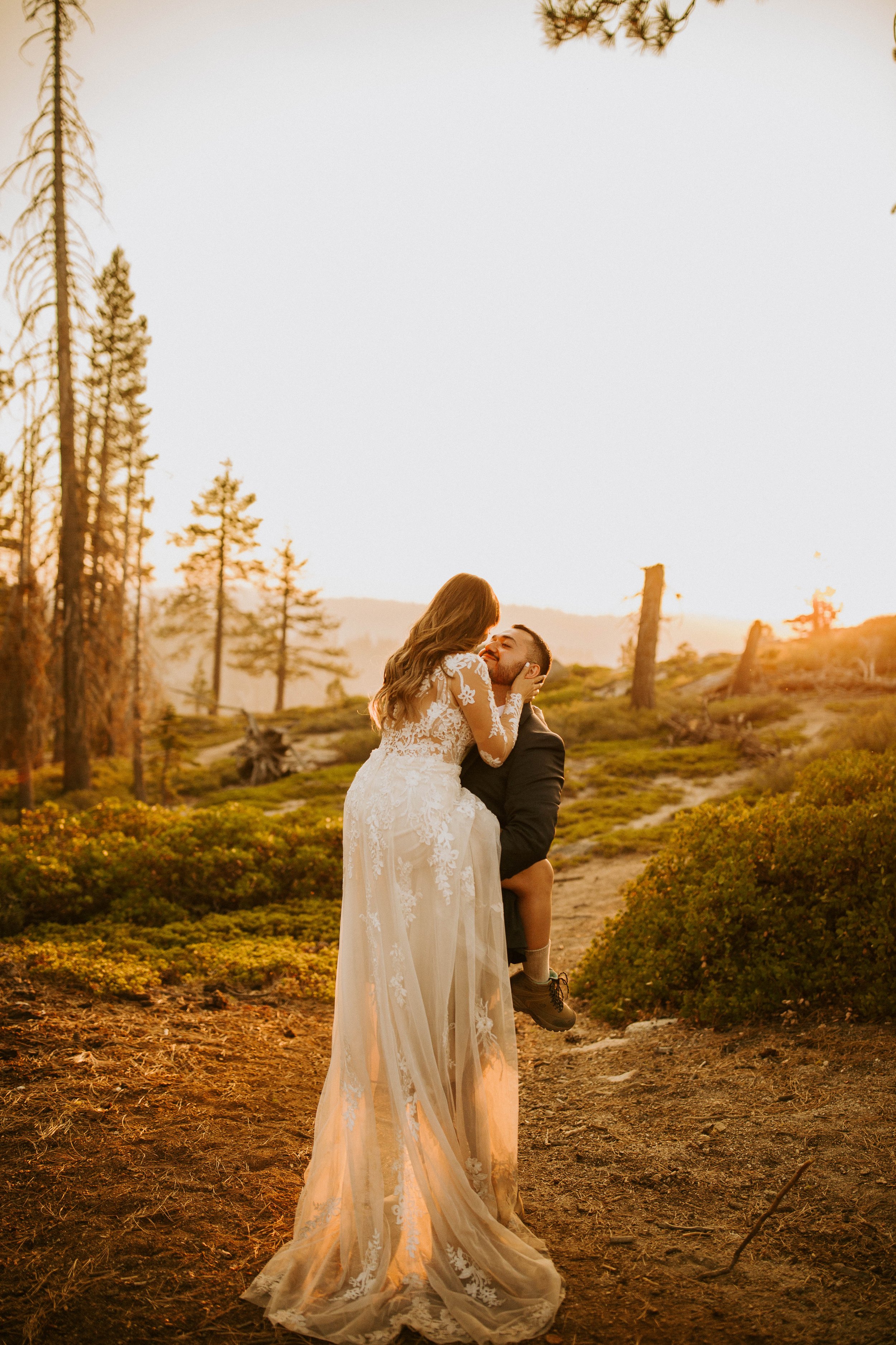 Groom lifting bride in a Galia Lahav wedding dress at Taft Point during sunset in Yosemite National Park.