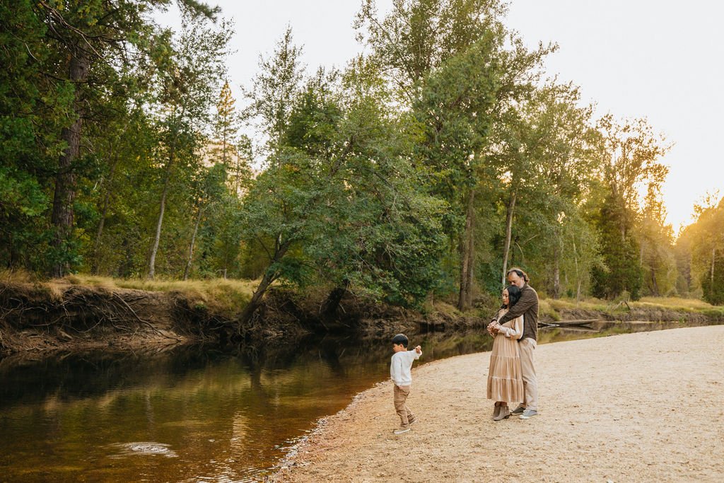 Family at Yosemite's Swinging Bridge at sunset with a young boy fishing.
