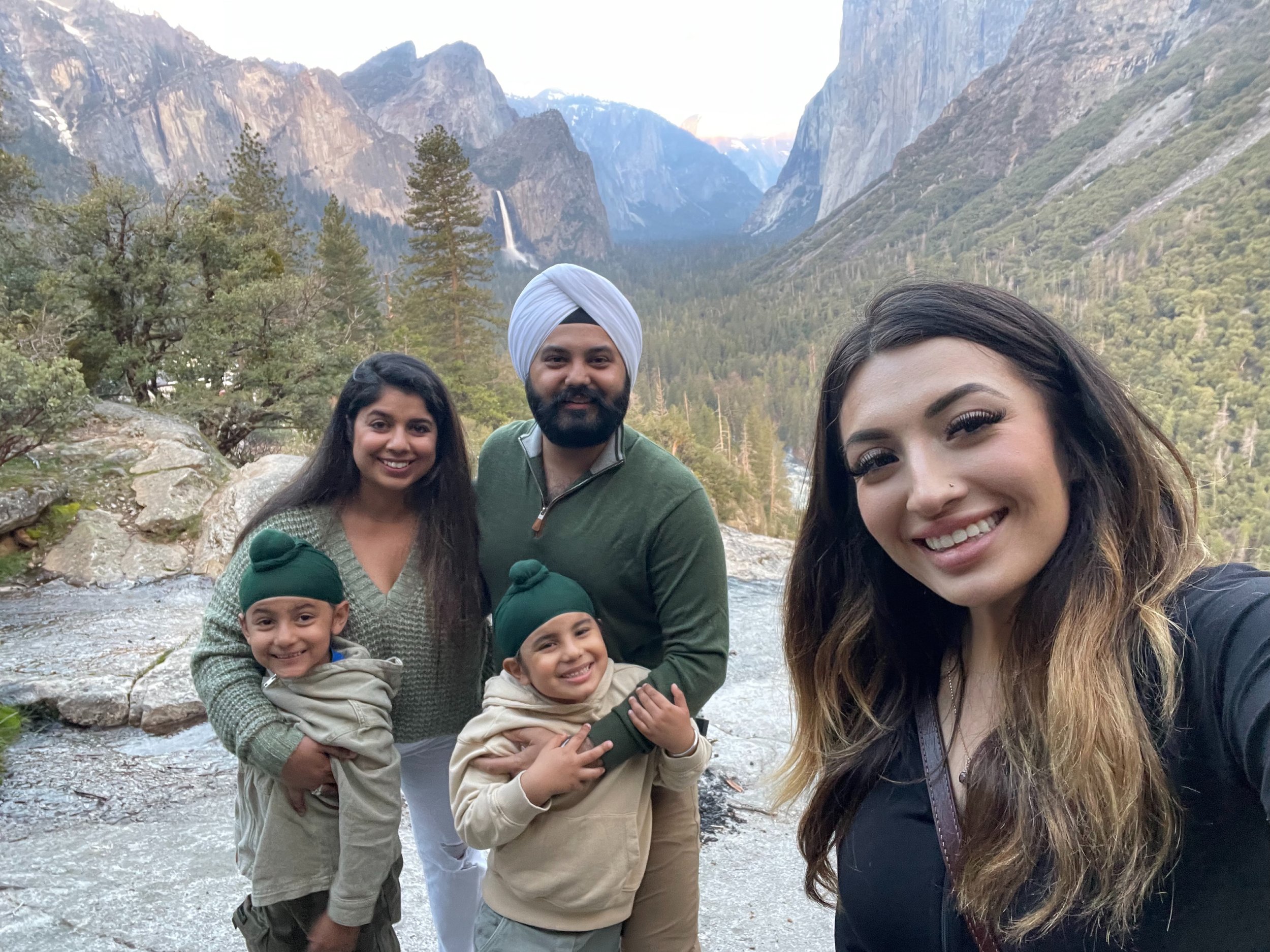 Yosemite photographer Priscilla Banuelos posing with a happy family at the Tunnel View overlook.