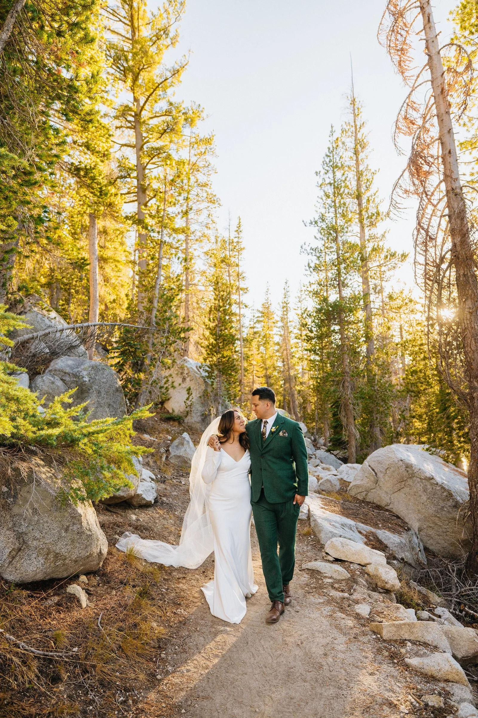 Bride and groom walk through Tioga Pass for wedding portraits