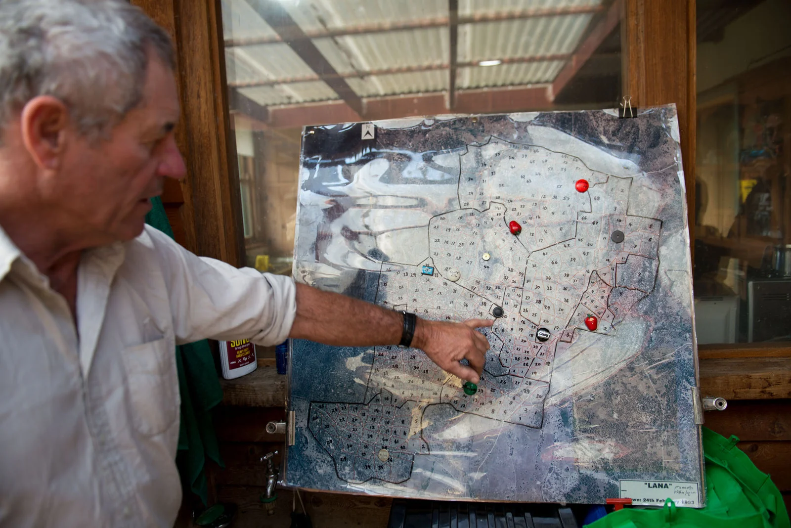 Tim with a map of his property that shows the small paddocks that his livestock move between following holistic management principles. Photo by Alex Wisser.