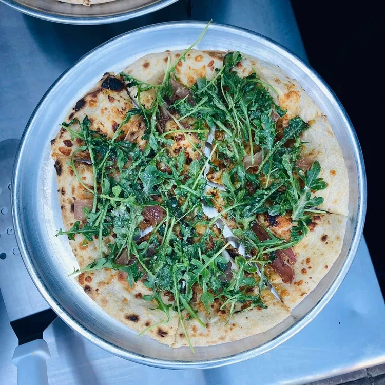 Fig and Pig pizza topped with prosciutto and arugula