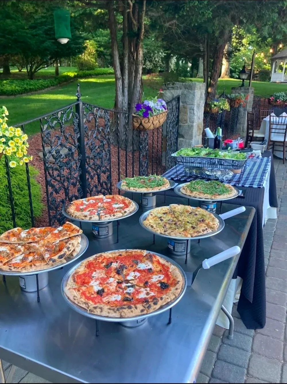 Vic and Nicalena's wood-fired pizzas and salad arranged for an outdoor catered event