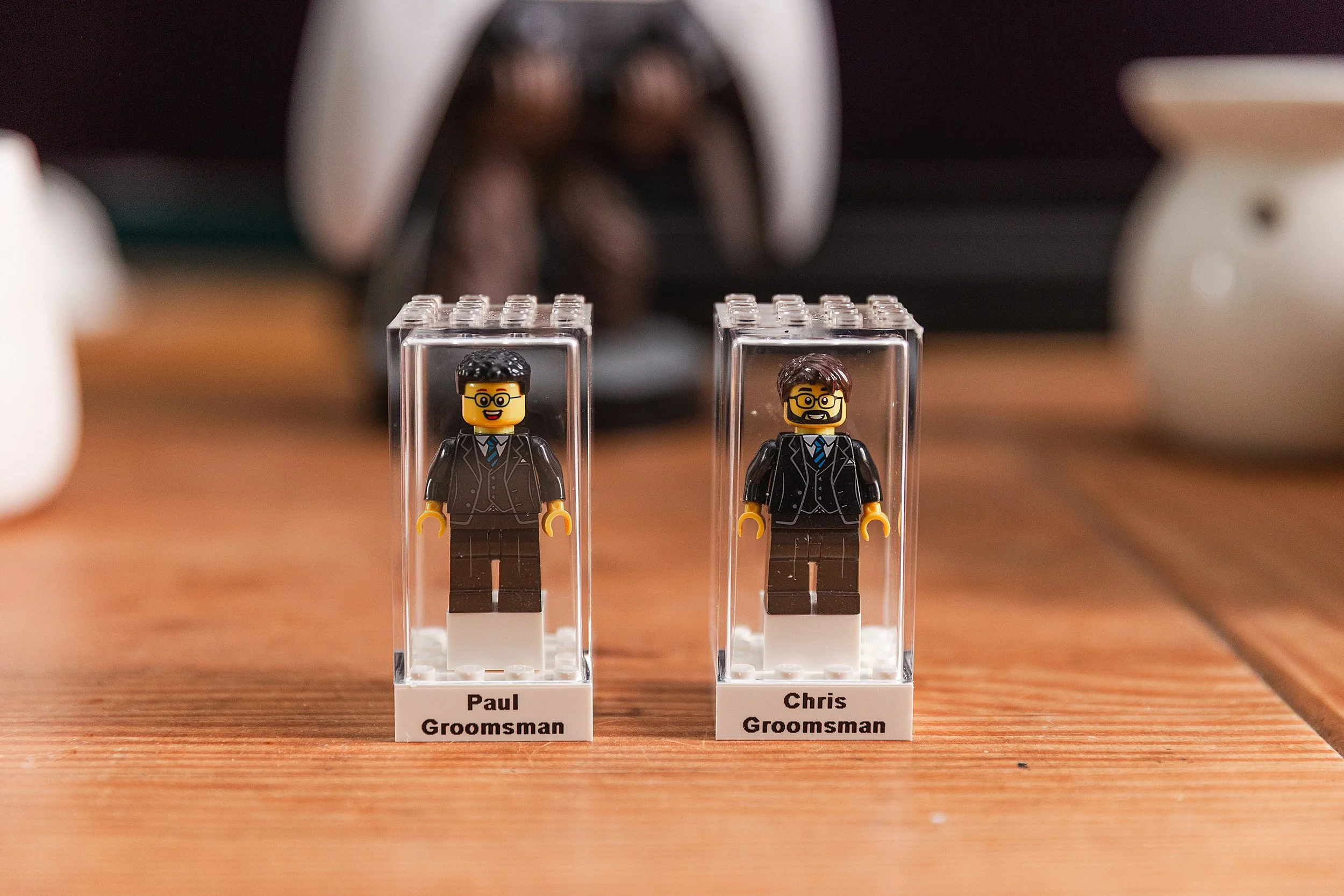 Two best men lego figures on top of a wooden table