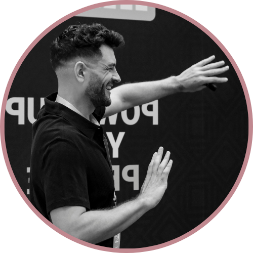 Image of Roy's profile as he speaks to an audience. He has a big smile and gesticulating with his hands