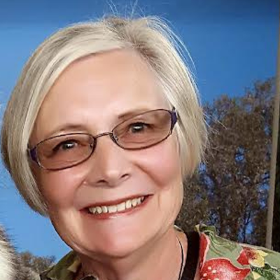 smiling middle-aged white woman with blonde hair and glasses
