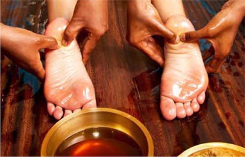 Black women massaging woman's feet