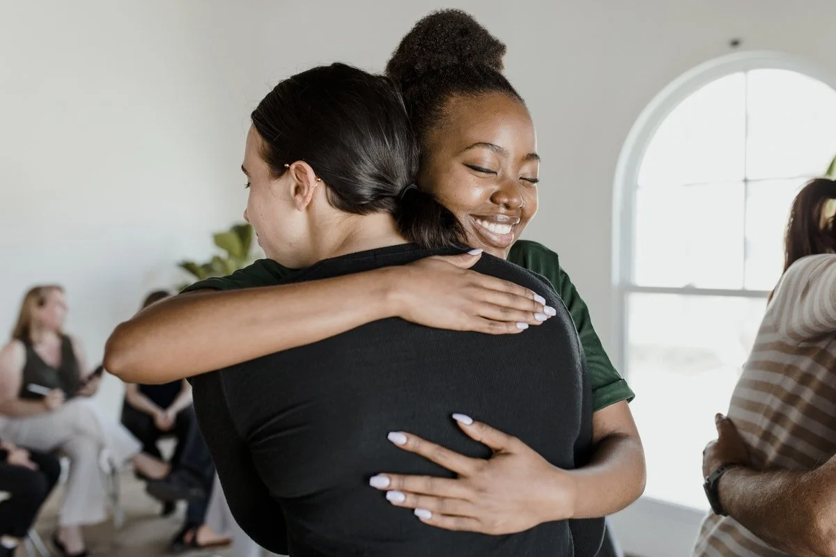 Black therapist hugging patient