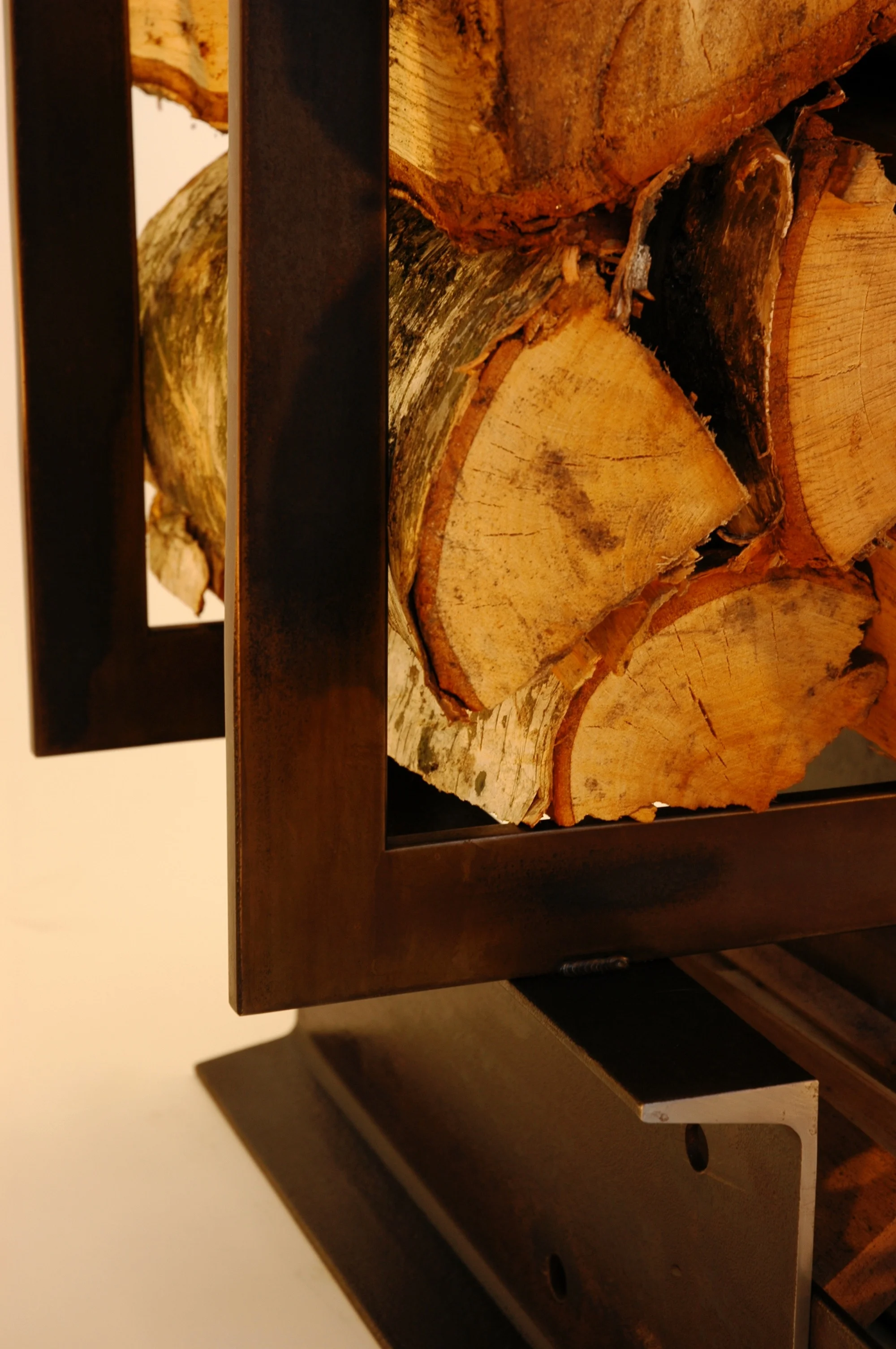 LOG TRUCK: This wood and kindling holder was fabricated from hot rolled steel flat bar and "C" channel. Brown/black patina.
