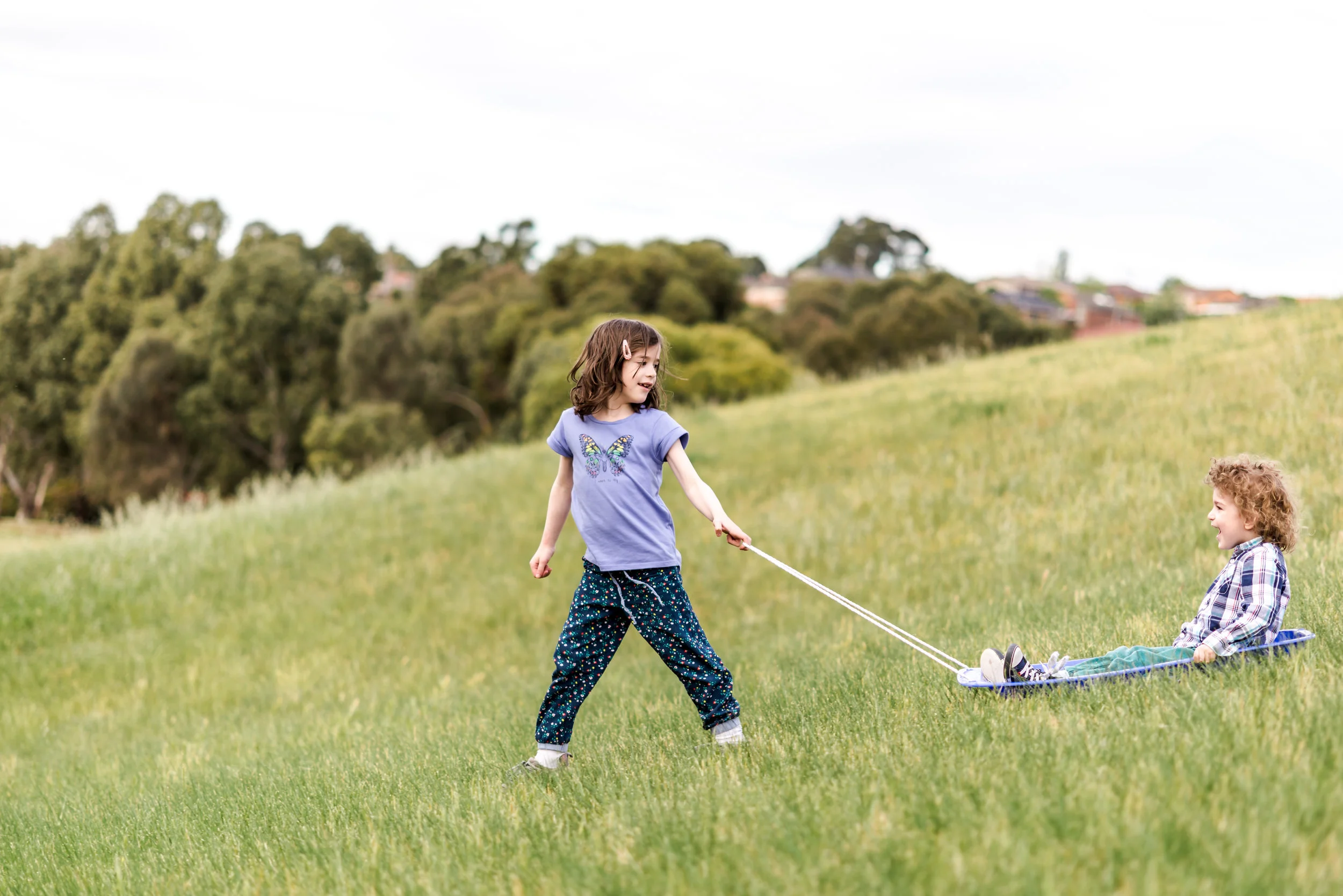 children grass sledding in park_SN14820.JPG