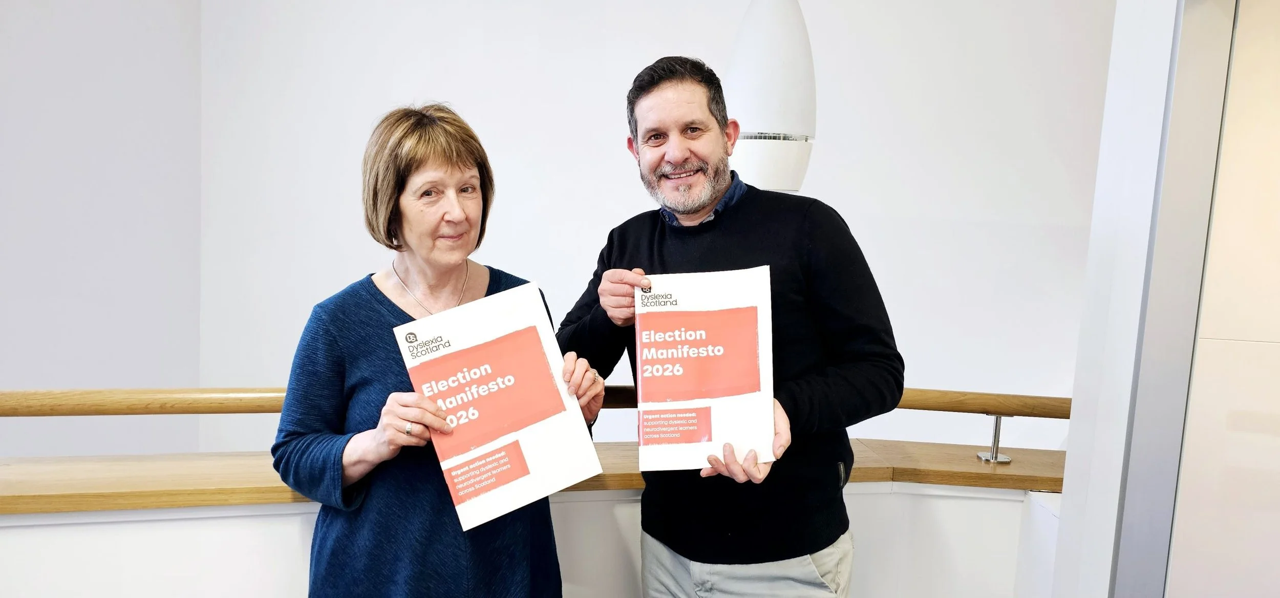 Dyslexia Scotland CEO Cathy Magee pictured alongside Dyslexia Scotland Ambassador Paul McNeill as they hold the Dyslexia Manifesto 2026