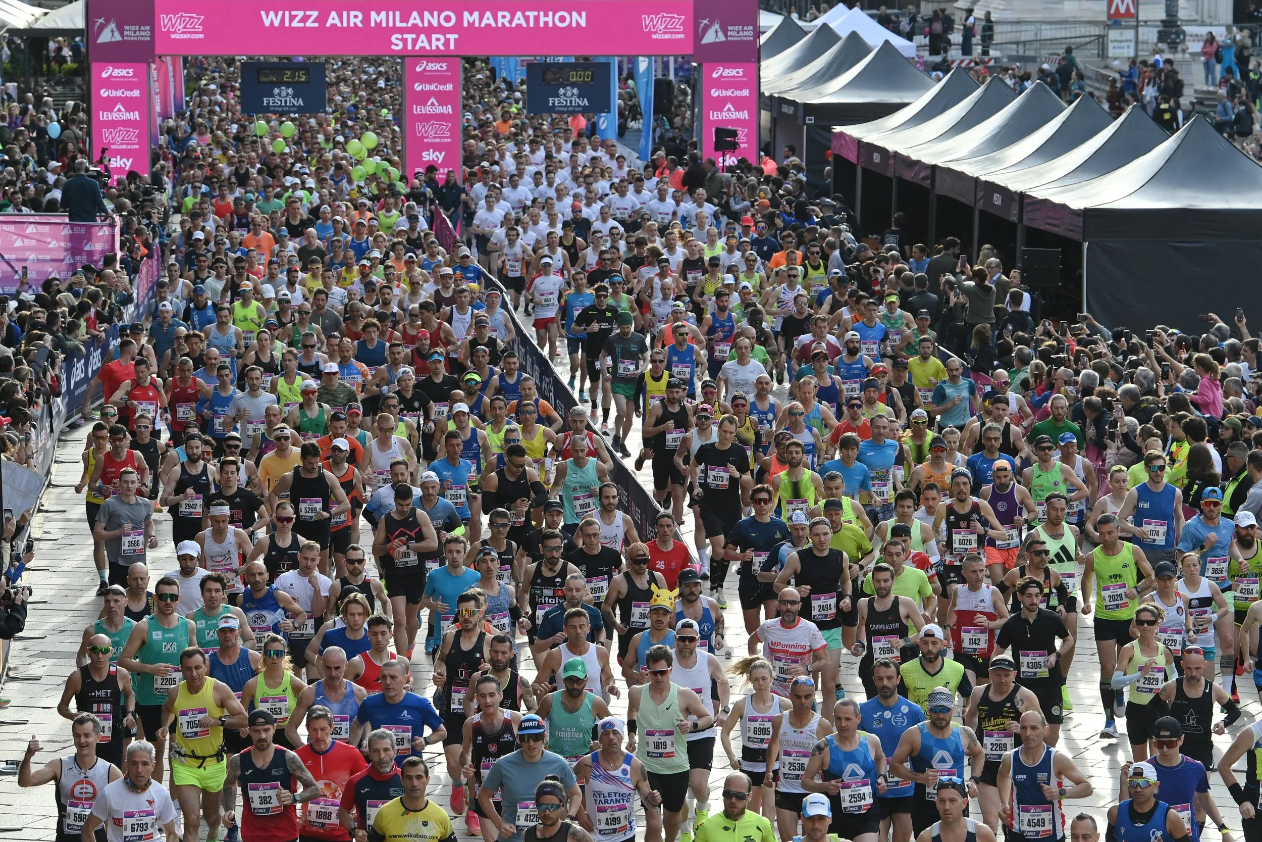 Thousands of runners crossing the start line of the Milano Marathon.