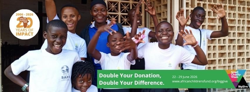 7 smiling Ugandan children in white t-shirts with their arms in the air, alongside an adult in the background.