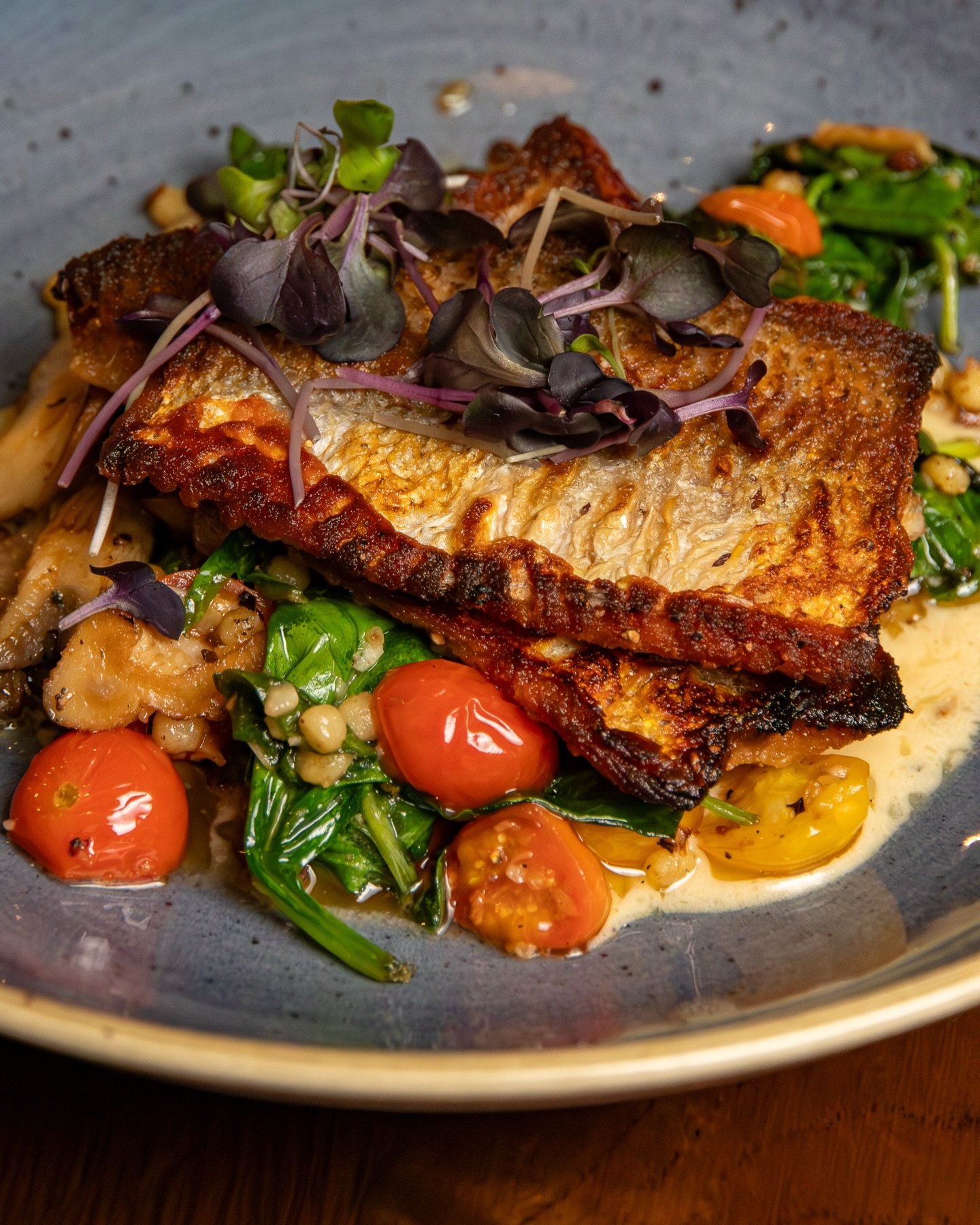 A winter plate that still feels bright: Lake Superior Whitefish, fregola, cremini mushrooms, spinach, cherry tomato, crispy carrot, lemon butter.