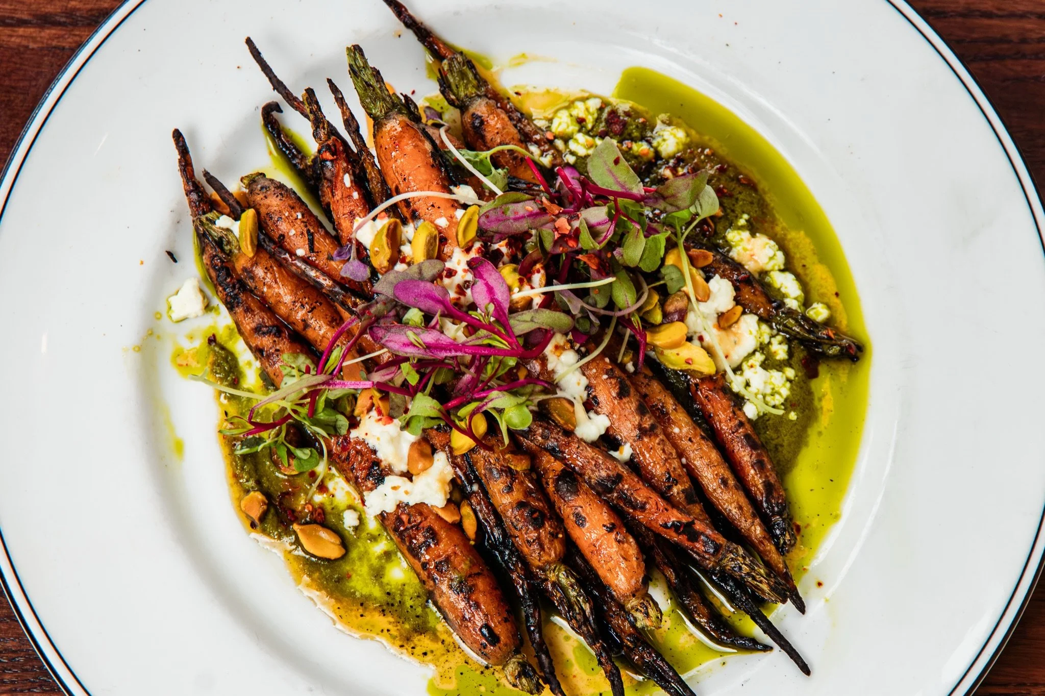 Charred over our wood-fired grill and finished with feta, aleppo honey, pistachio, and fennel salsa verde. The kind of vegetable dish that steals the table. 🔥🥕