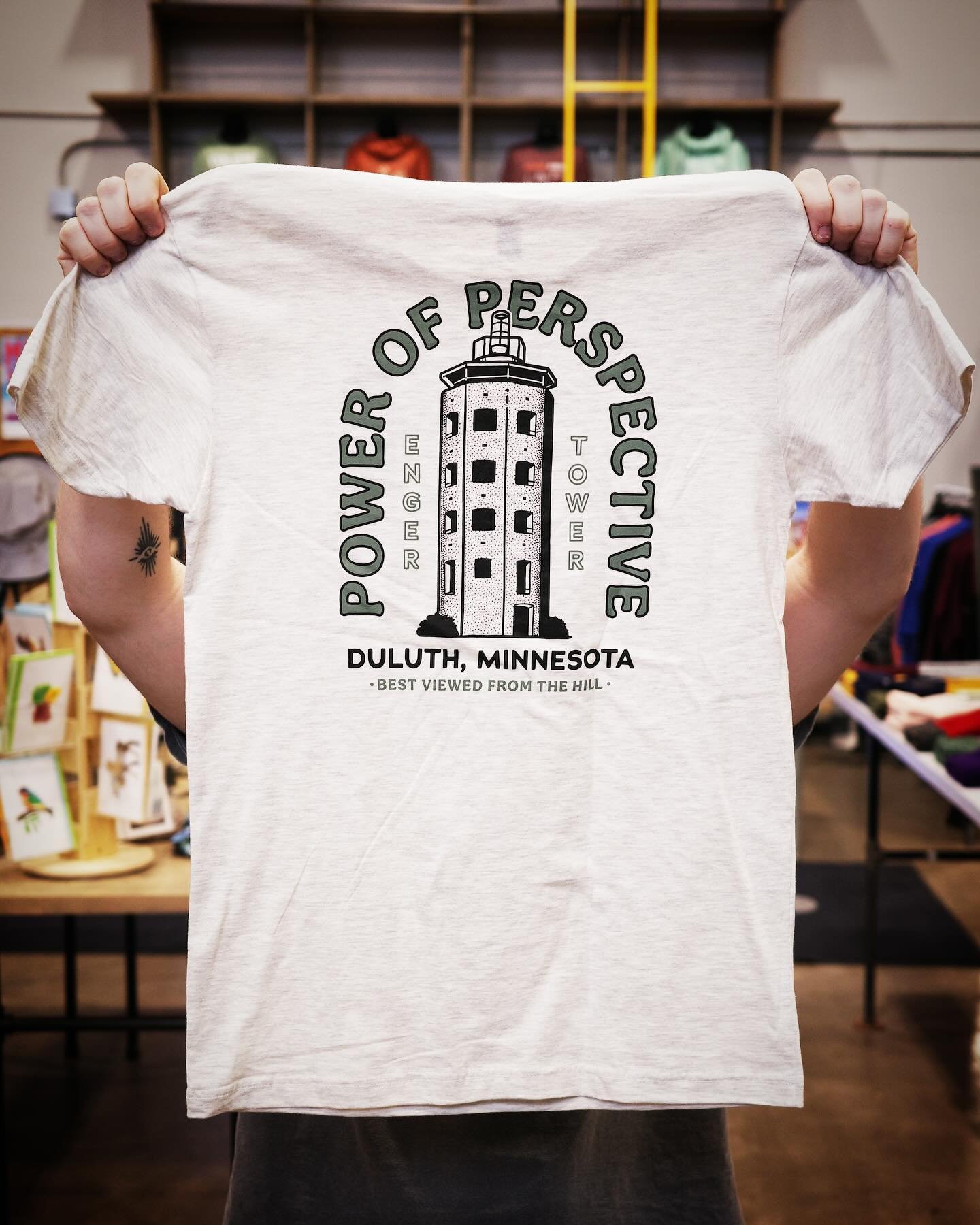 📈 POWER OF PERSPECTIVE 👀
&bull;
NEW ARRIVALS are starting to hit the shelves! This one is giving our Enger Tower some real love, featuring design work from our company pal, Sean. Available very soon, in limited quantities both in-store and online! 