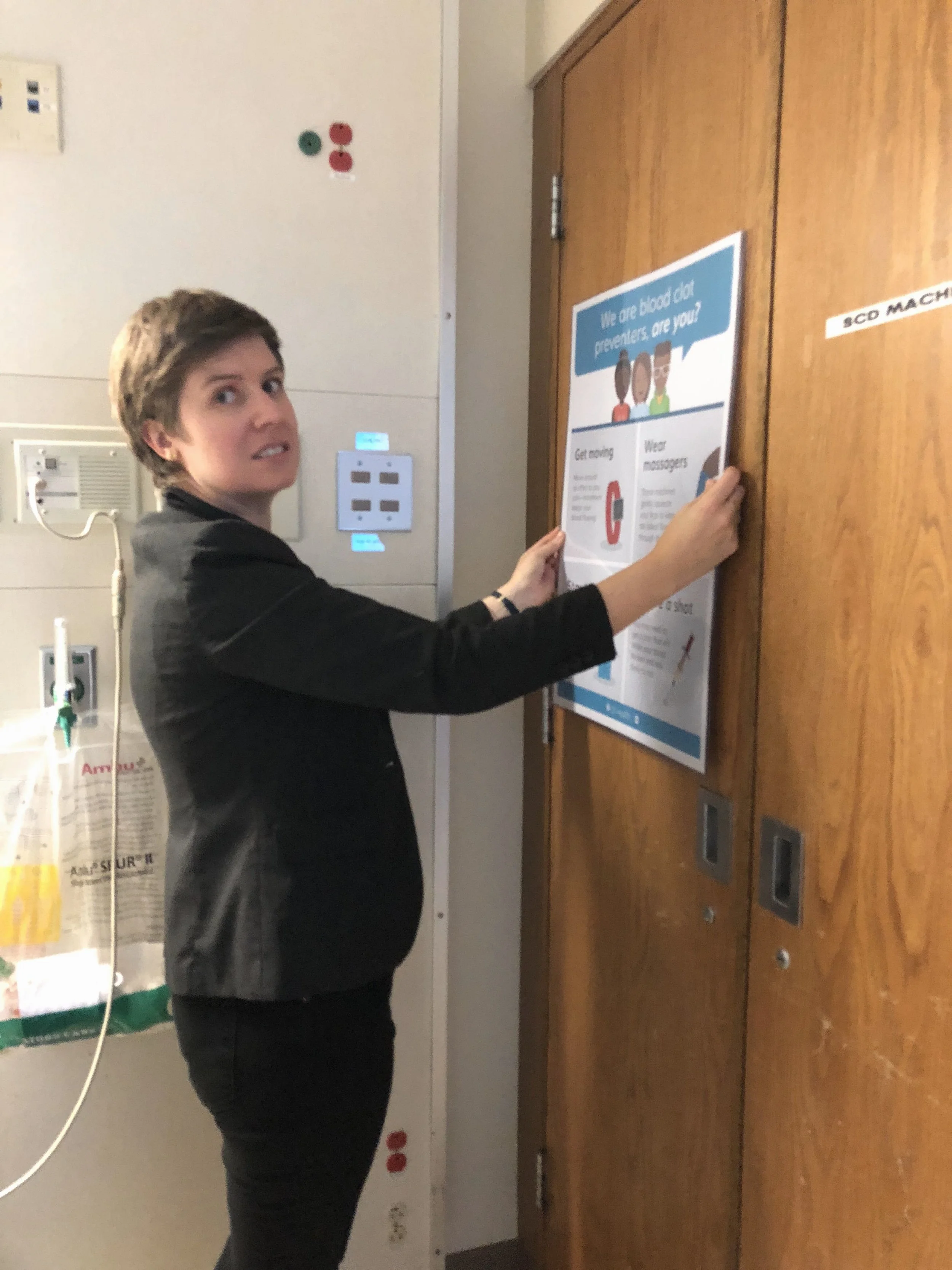 Sarah putting up poster.JPG