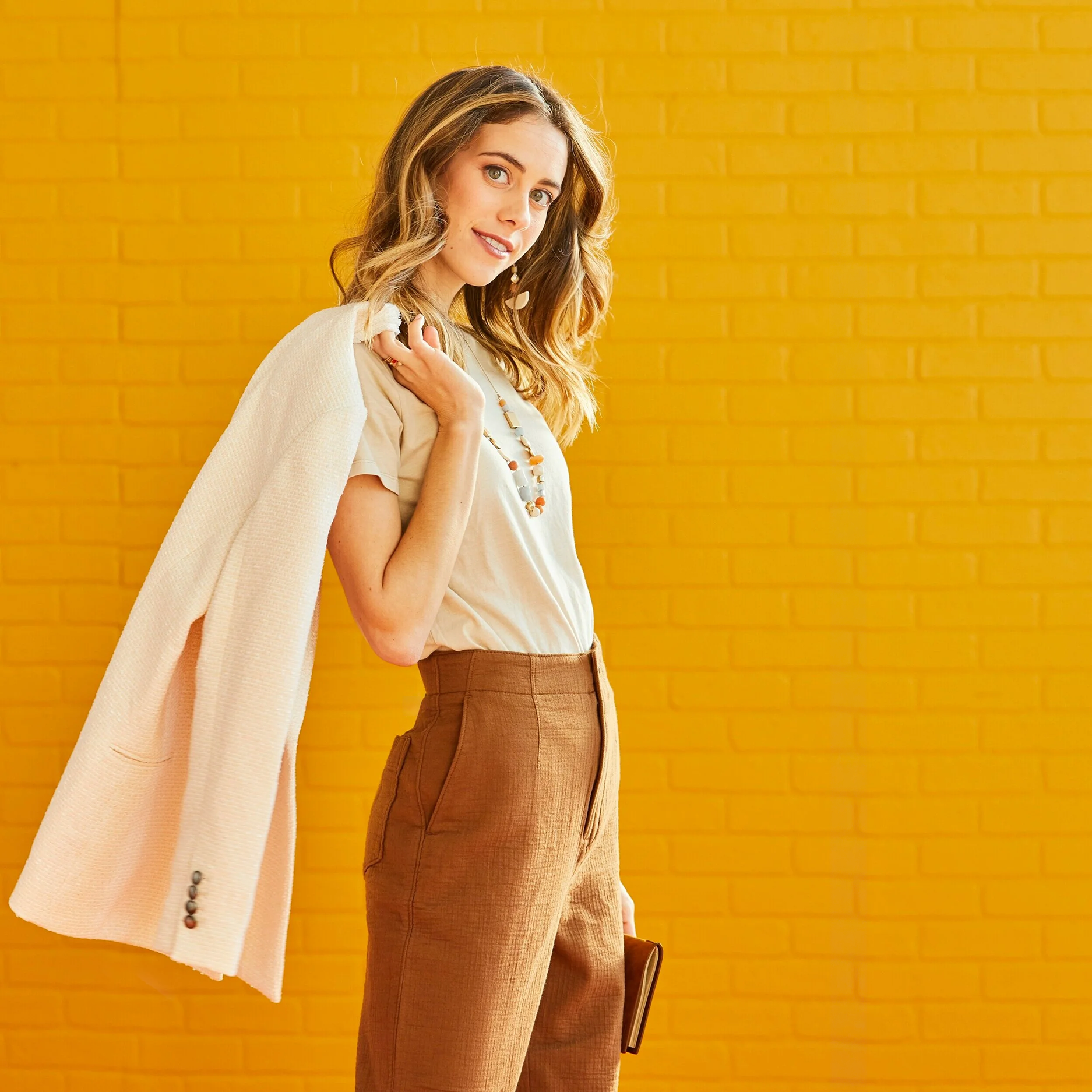 Lucie Fink holding cream jacket over her shoulder