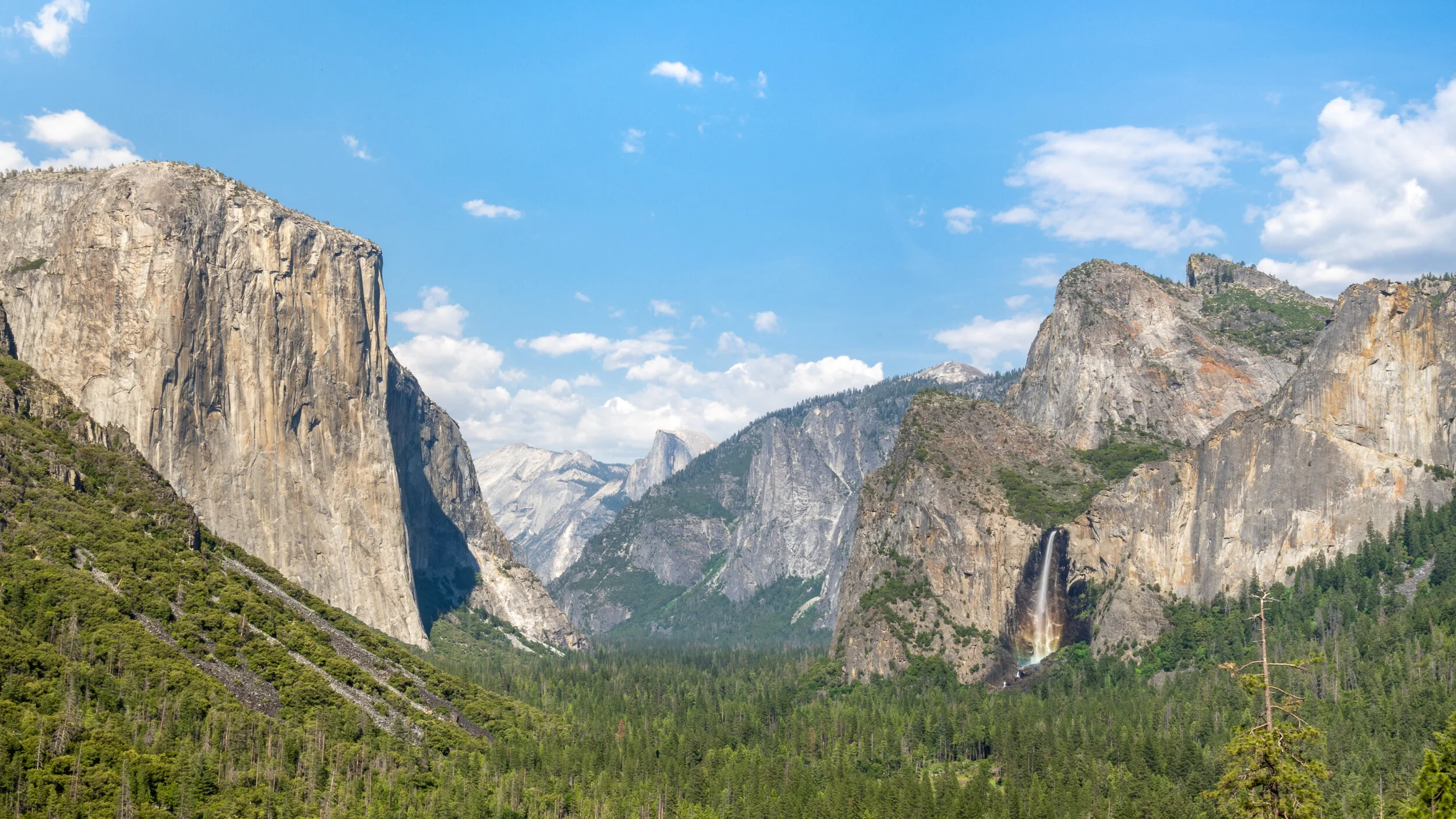 Tunnel View Overlook in Mid-Afternoon - El Capitan (left), Half Dome (center rear), and Bridalviel Falls (right) w/Rainbow rising up the Falls.