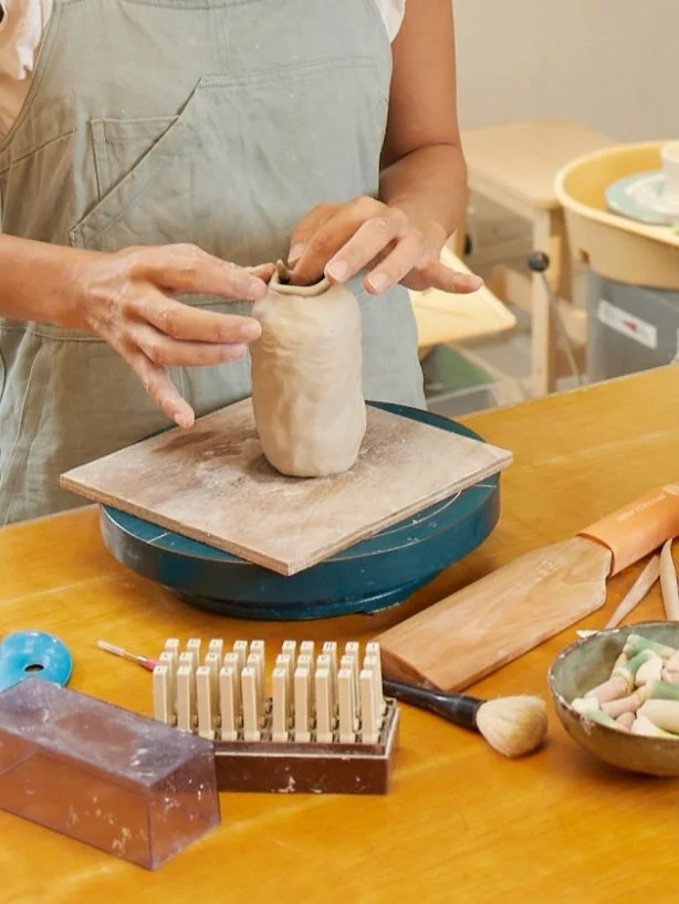 person using their fingers to coil handbuilt clay