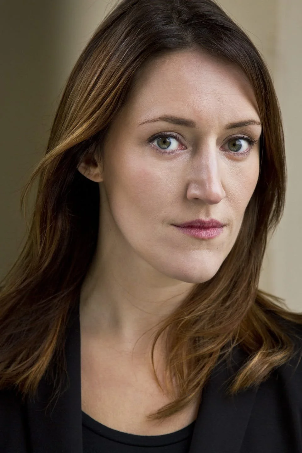 Ruth Worth, headshot photo, with brown hair and green eyes, wearing a black top, looking at the camera with a neutral expression.
