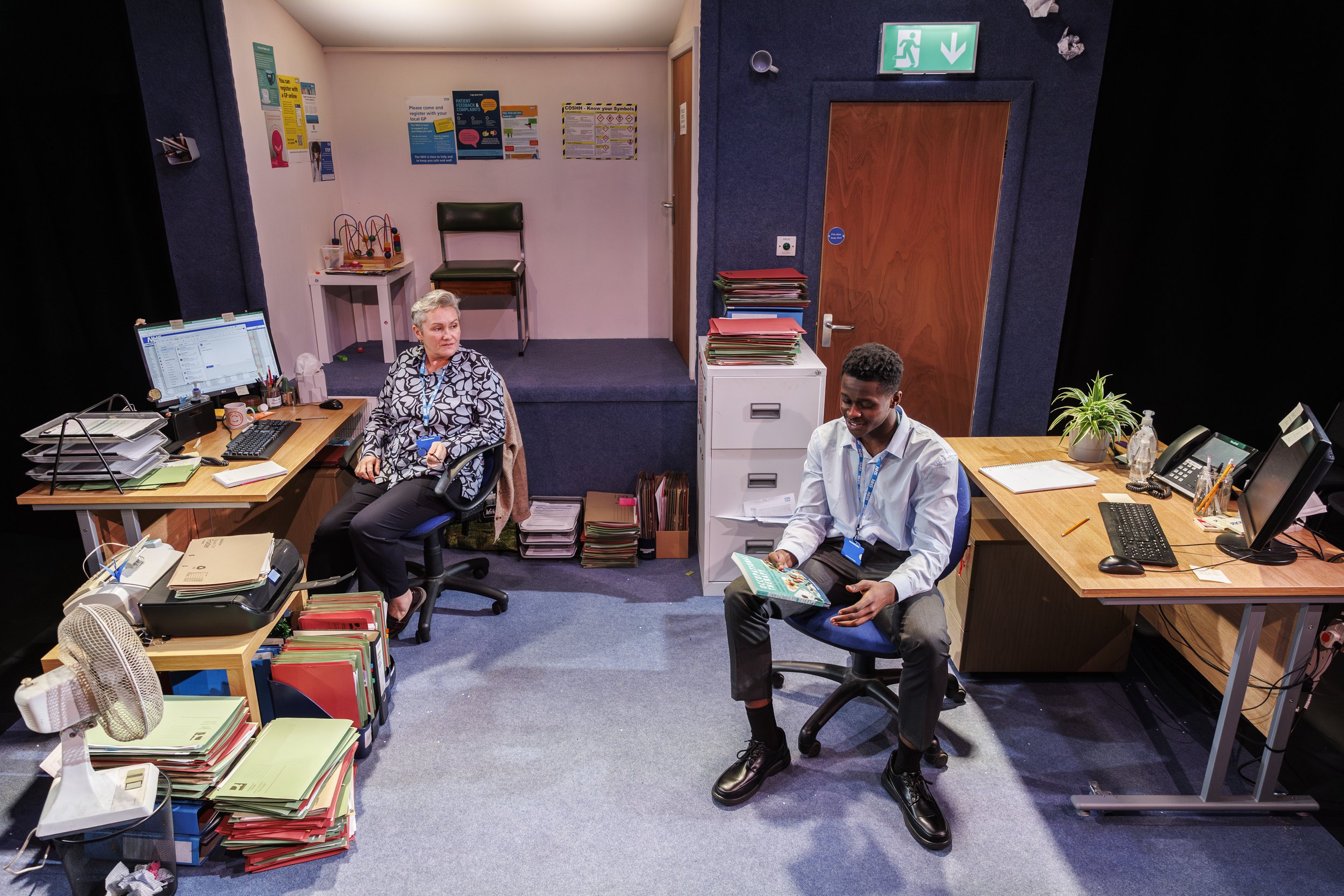  London Theatre: “Every detail has been considered in Alys Whitehead’s realist … set design. Stacks of files clutter every available surface, waste paper baskets overflow in corners of the room, and a small reception area covered in NHS support poste