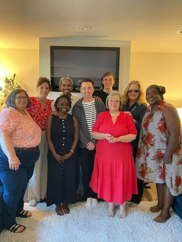 Our international Prophetic small group containing a diverse group of ten people, including men and women of various ages and ethnicities, posing together in a living room, smiling for the camera.