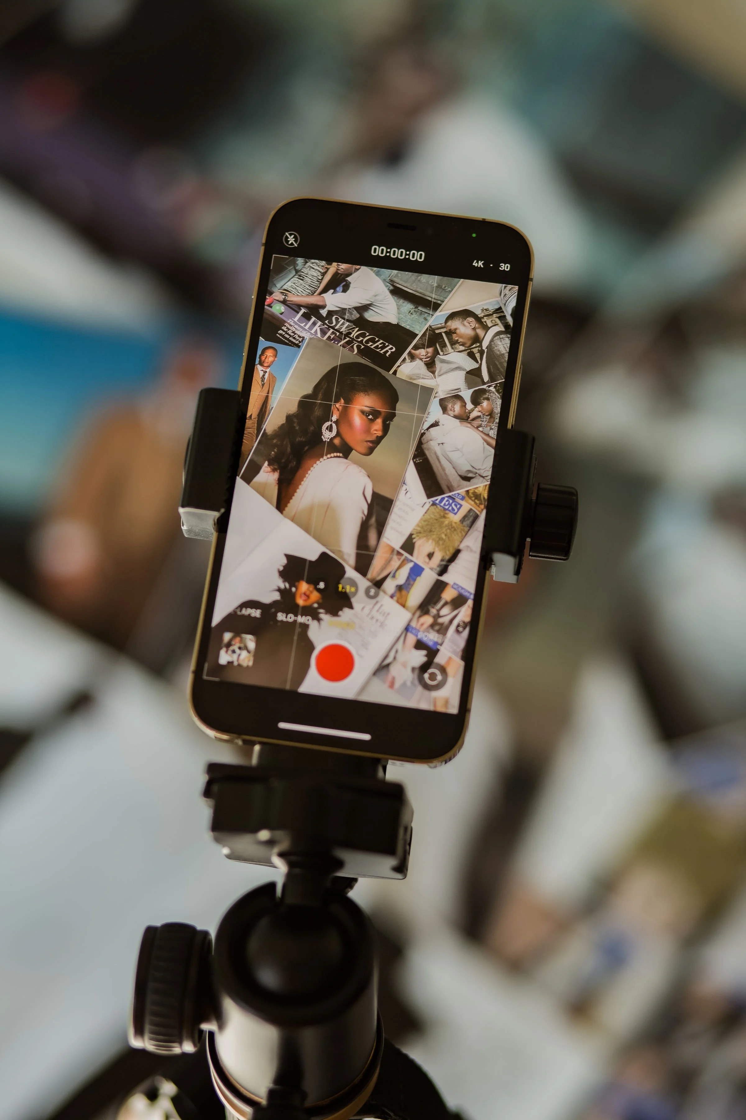 Smartphone mounted on tripod recording a photoshoot of people in a studio.