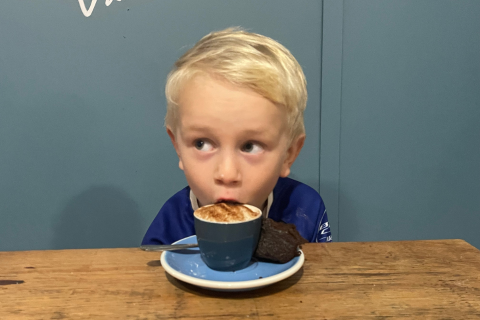 Little boy drinking a fluffy out of a cup