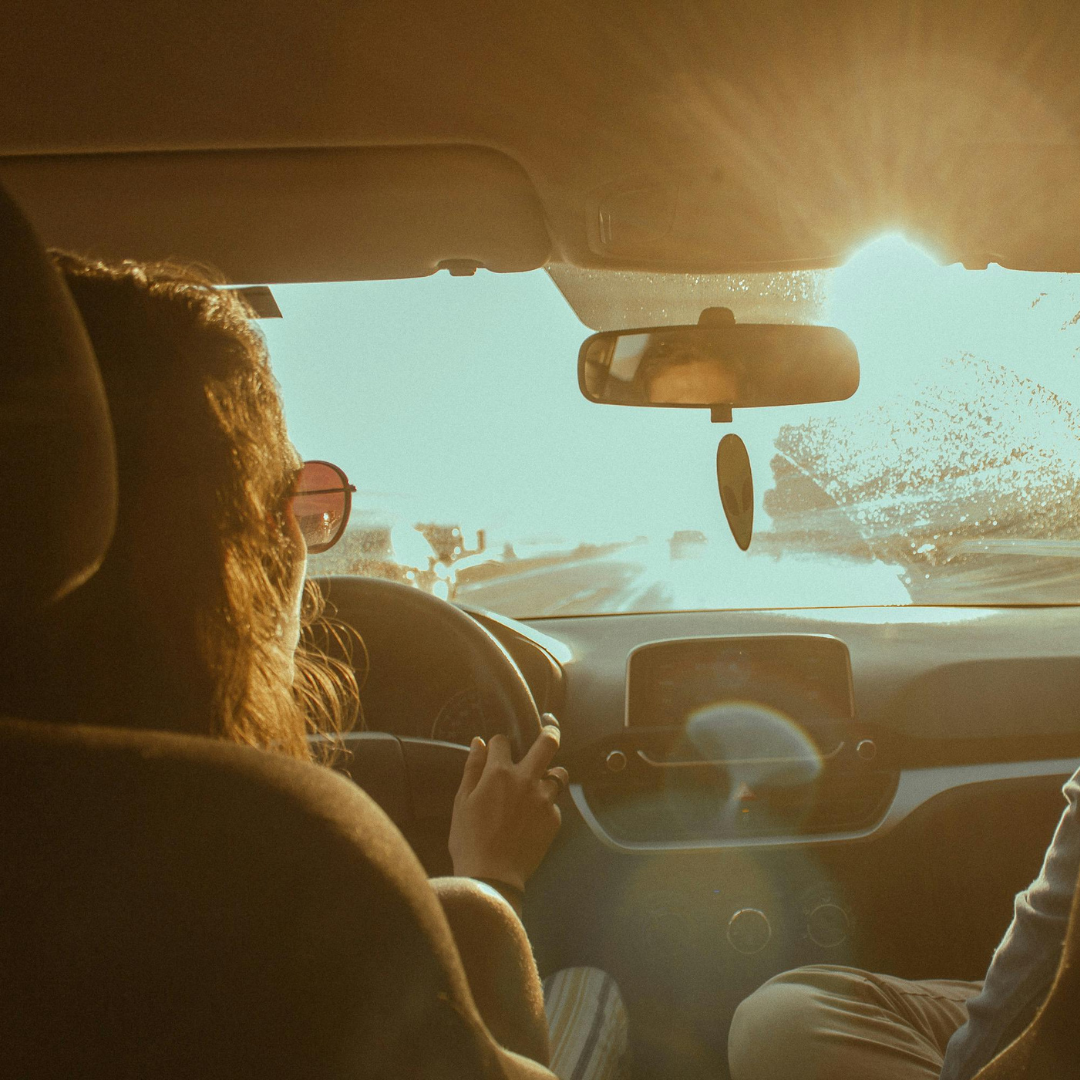 Woman driving with sun glaring into the windshield