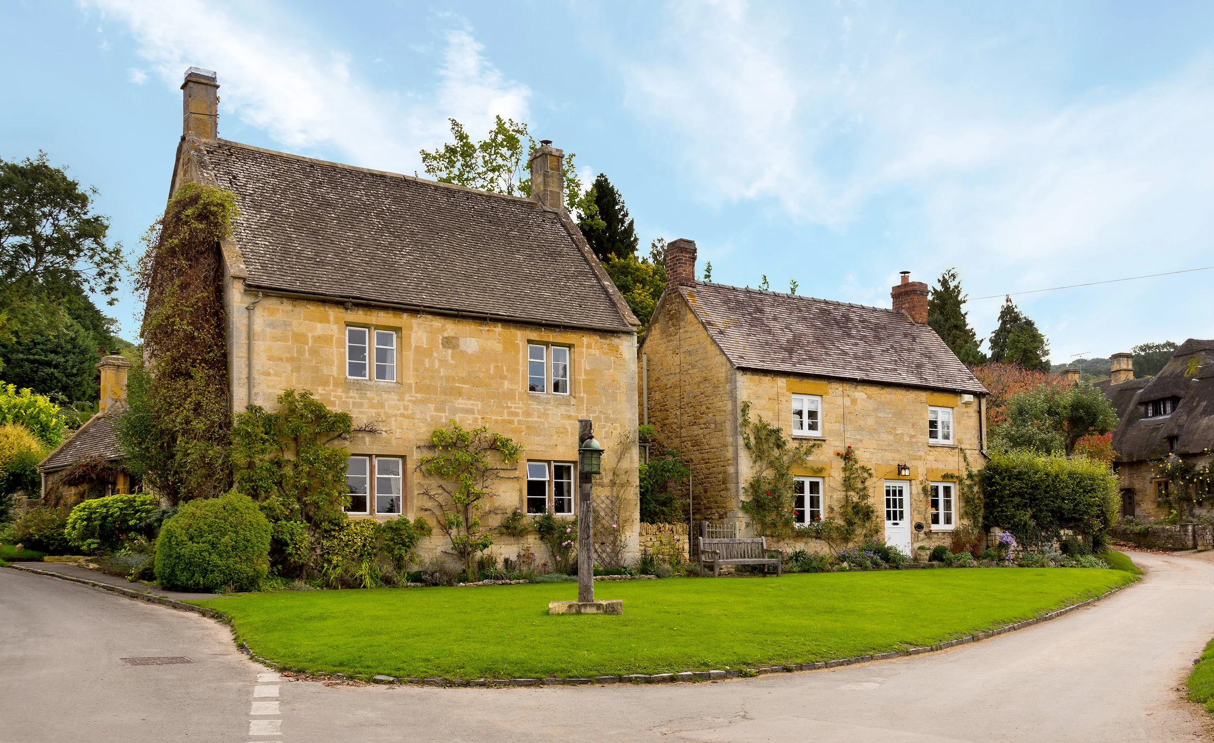 Beautiful sandstone village country cottages on road blue sky retouching