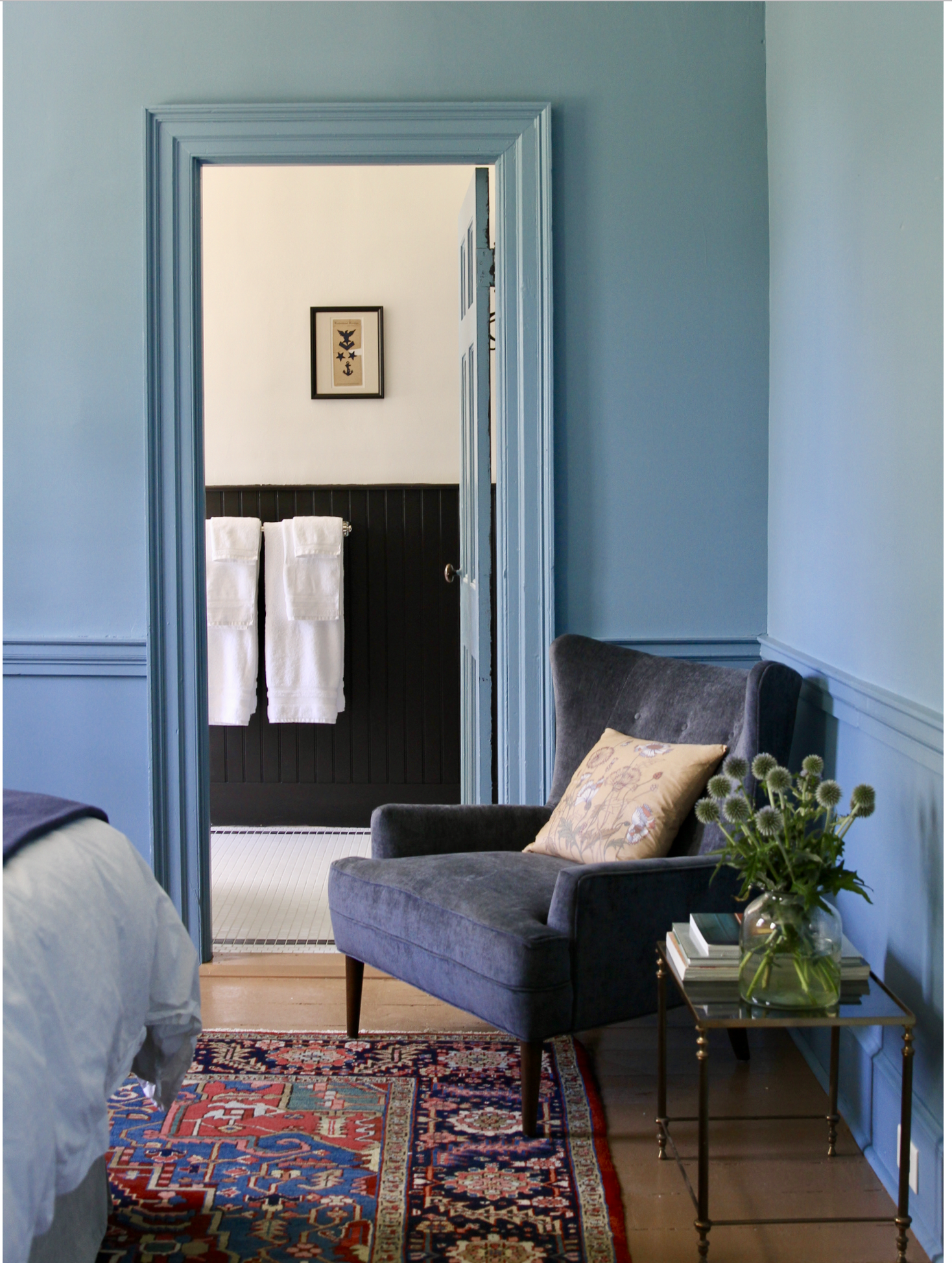 Room Five A monochrome blue provides a rich but restful backdrop for a vintage Persian rug, brass chandelier, and selected art work. Comfortable seating is something you'll find here, and in the many public areas throughout the house.