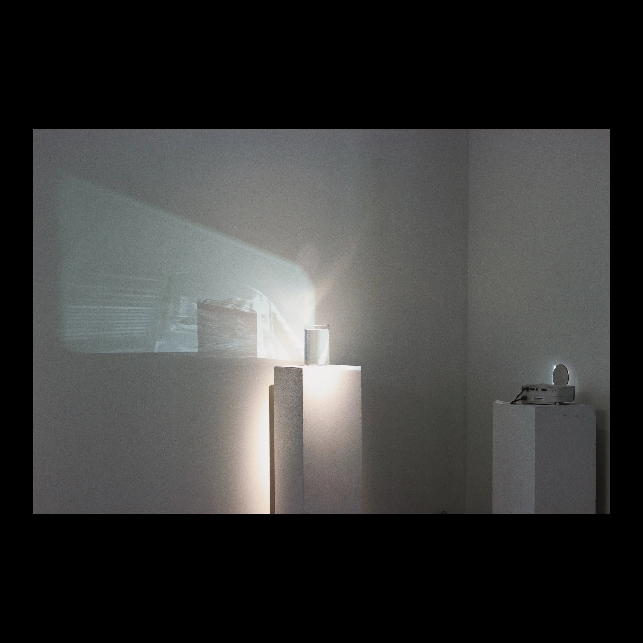 the further distortion cont. (tap tap are you in there fear is valid play is valid curiosity is valid i’m valid i’m valid i’m valid in the lost because we are all lost maybe i should dig myself out) , 2019 glass, water, mirror, digital projection of 16mm film : 0:2:39s